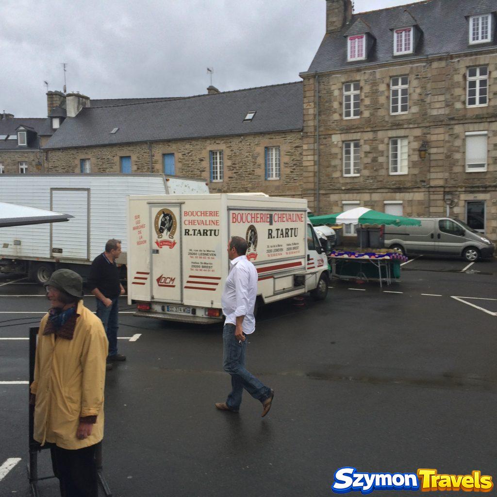 Targ w Tréguier z samochodem boucherie chevaline i kamiennymi domami w tle