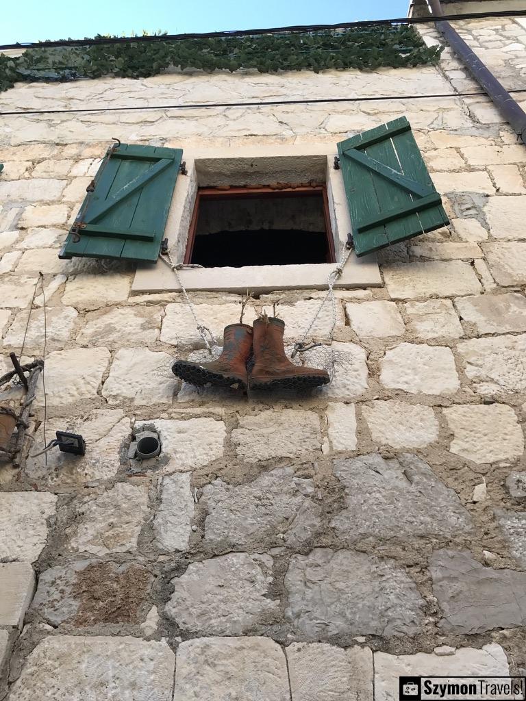 Buty zwisają z okienicy w Primošten, Chorwacja