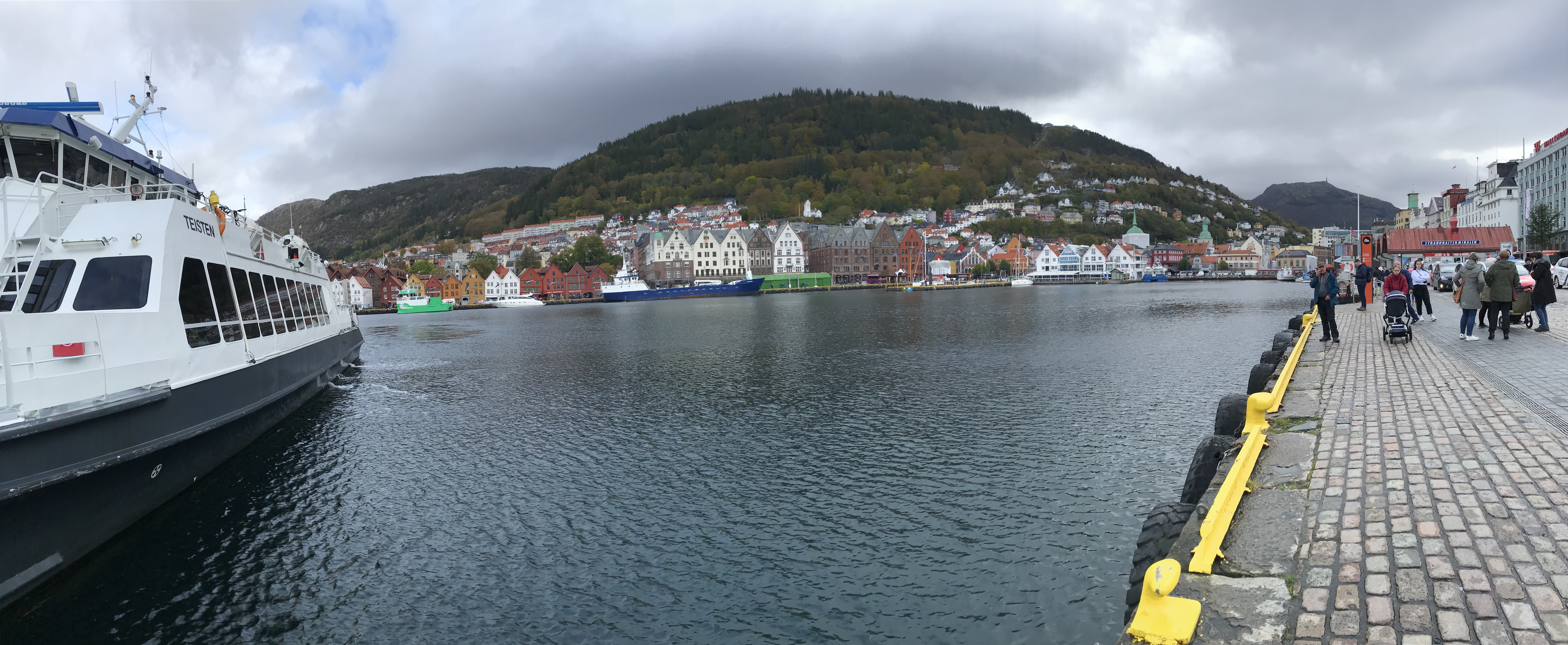 Port w Bergen, Bryggen i góry Panorama portu w Bergen z promem, Bryggen i górami w tle