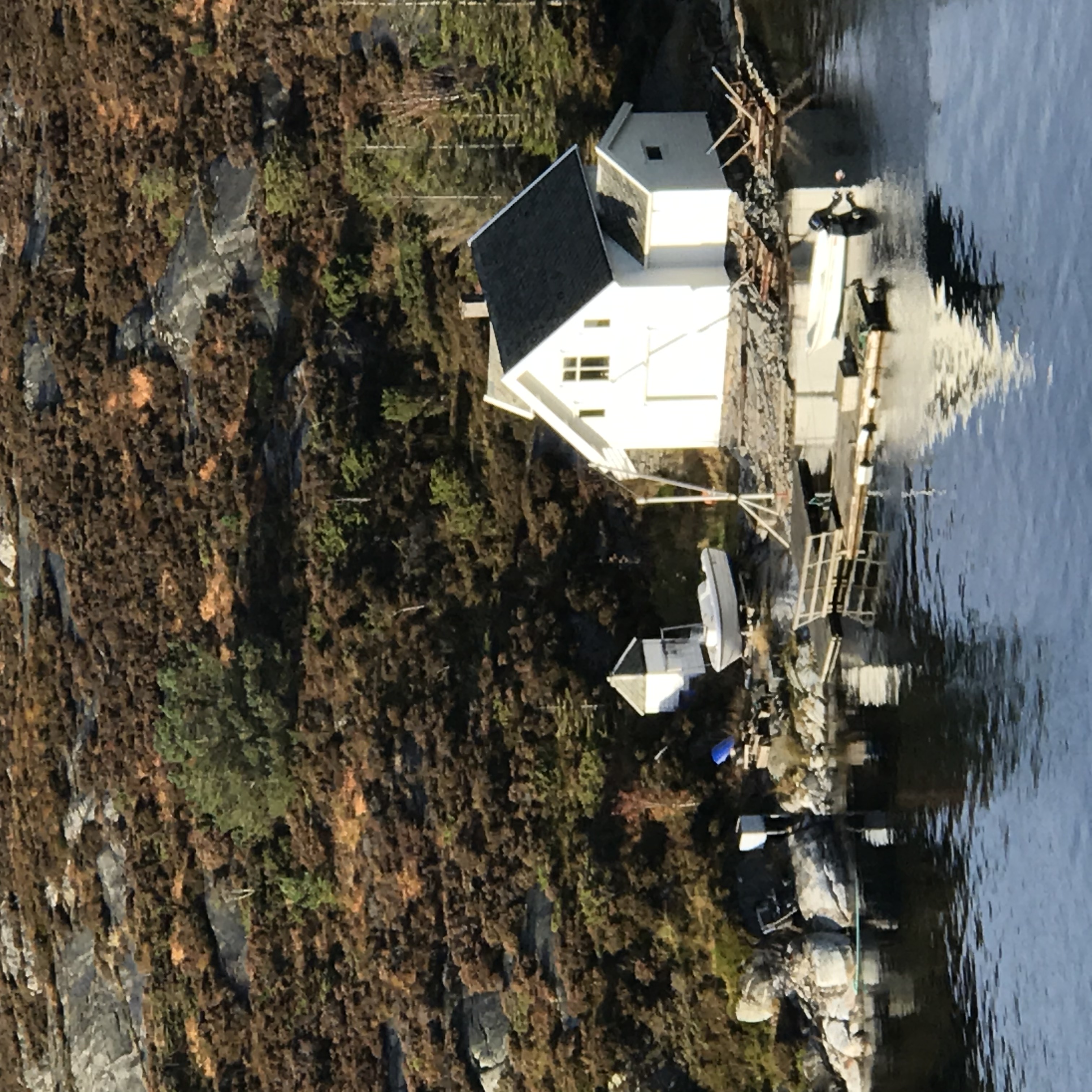 Biały dom nad wodą w skalistej zatoce na wyspie Sotra w Norwegii