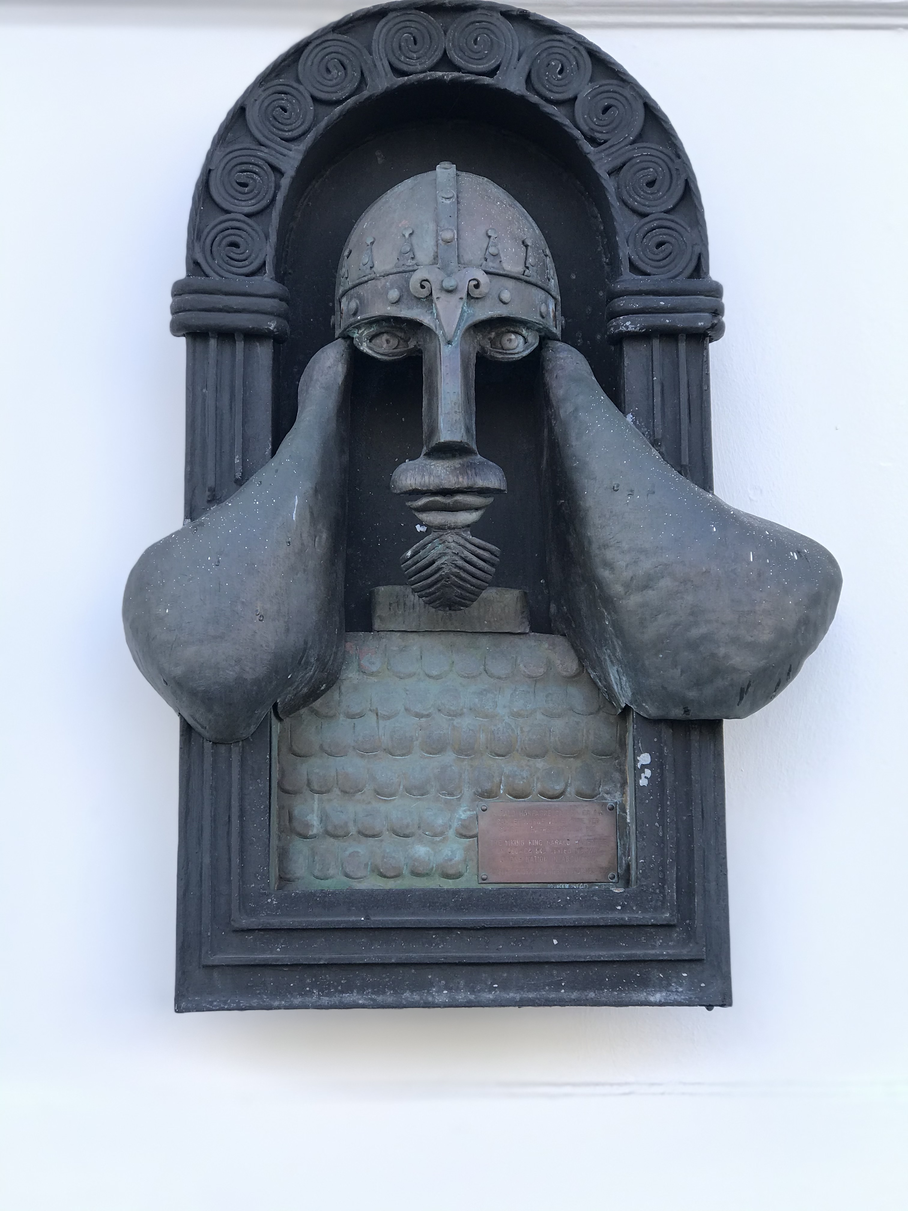 Płaskorzeźba głowy w hełmie wikińskim Metalowa płaskorzeźba głowy w hełmie wikińskim na ścianie w Bergen