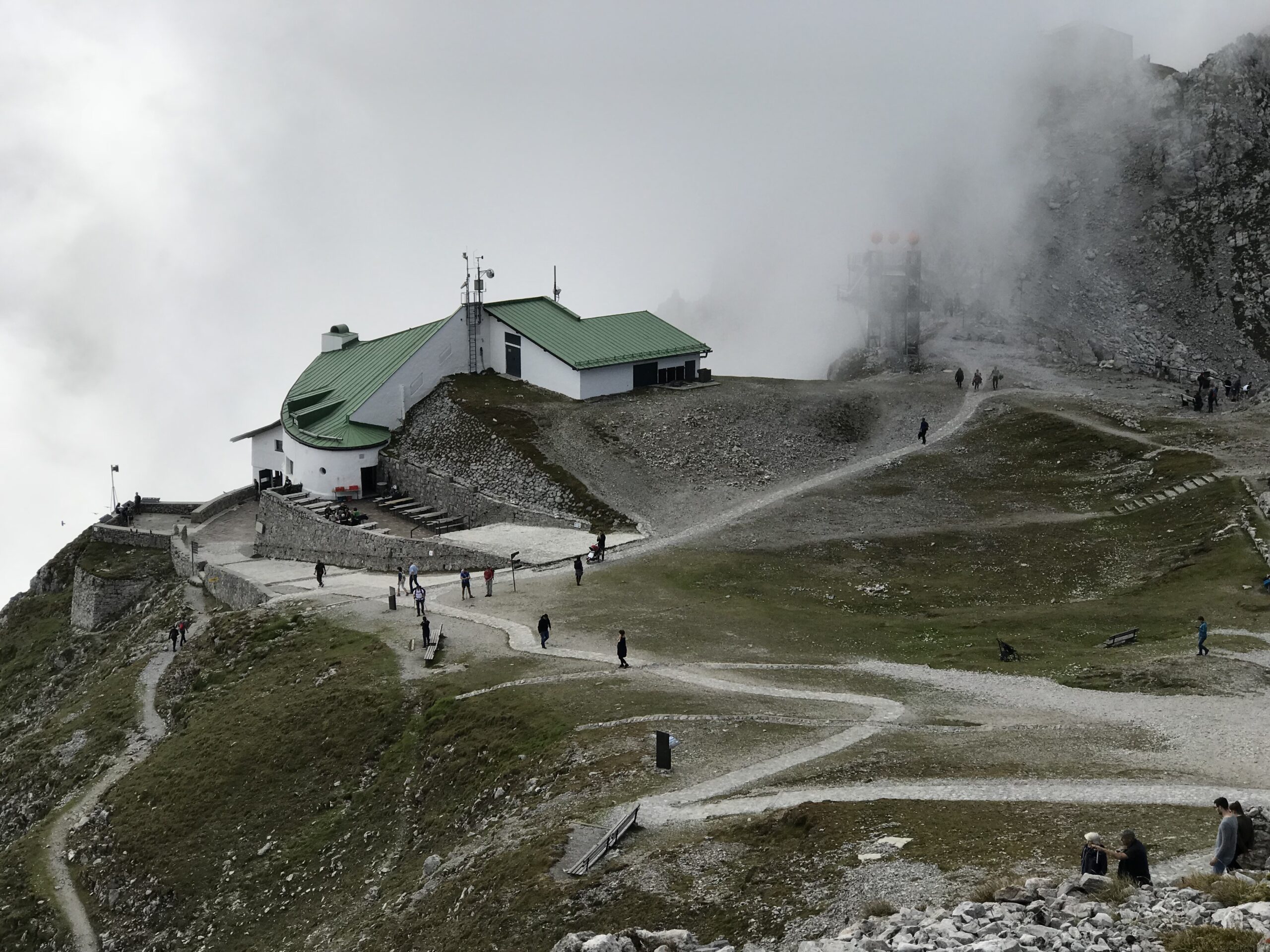 Seegrube na Nordkette Rejon Seegrube na Nordkette z budynkiem stacji, ścieżkami, chmurami i turystami nad Innsbruckiem