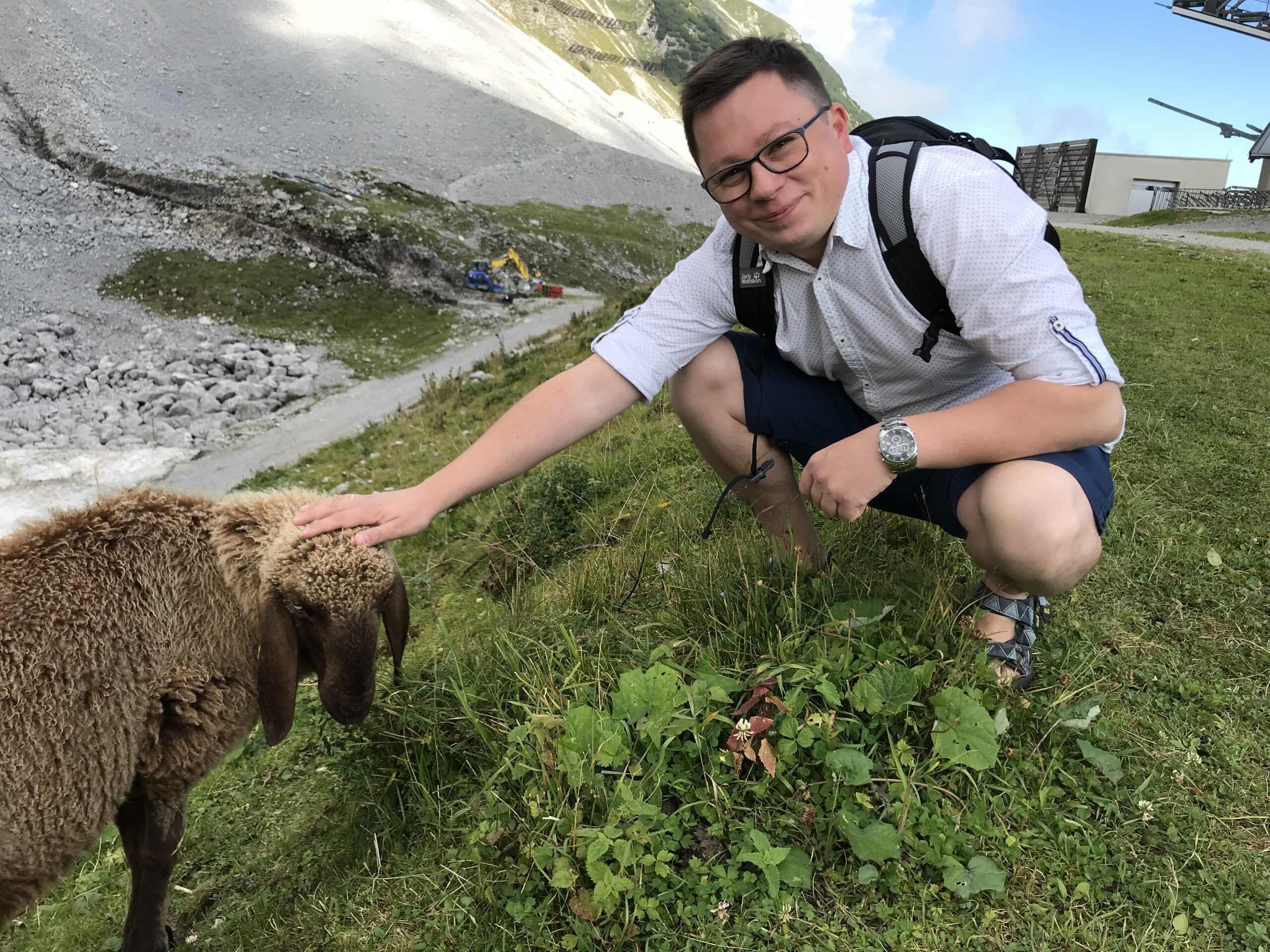 Szymon z owcą na Nordkette Szymon kucający przy owcy na alpejskim zboczu Nordkette nad Innsbruckiem