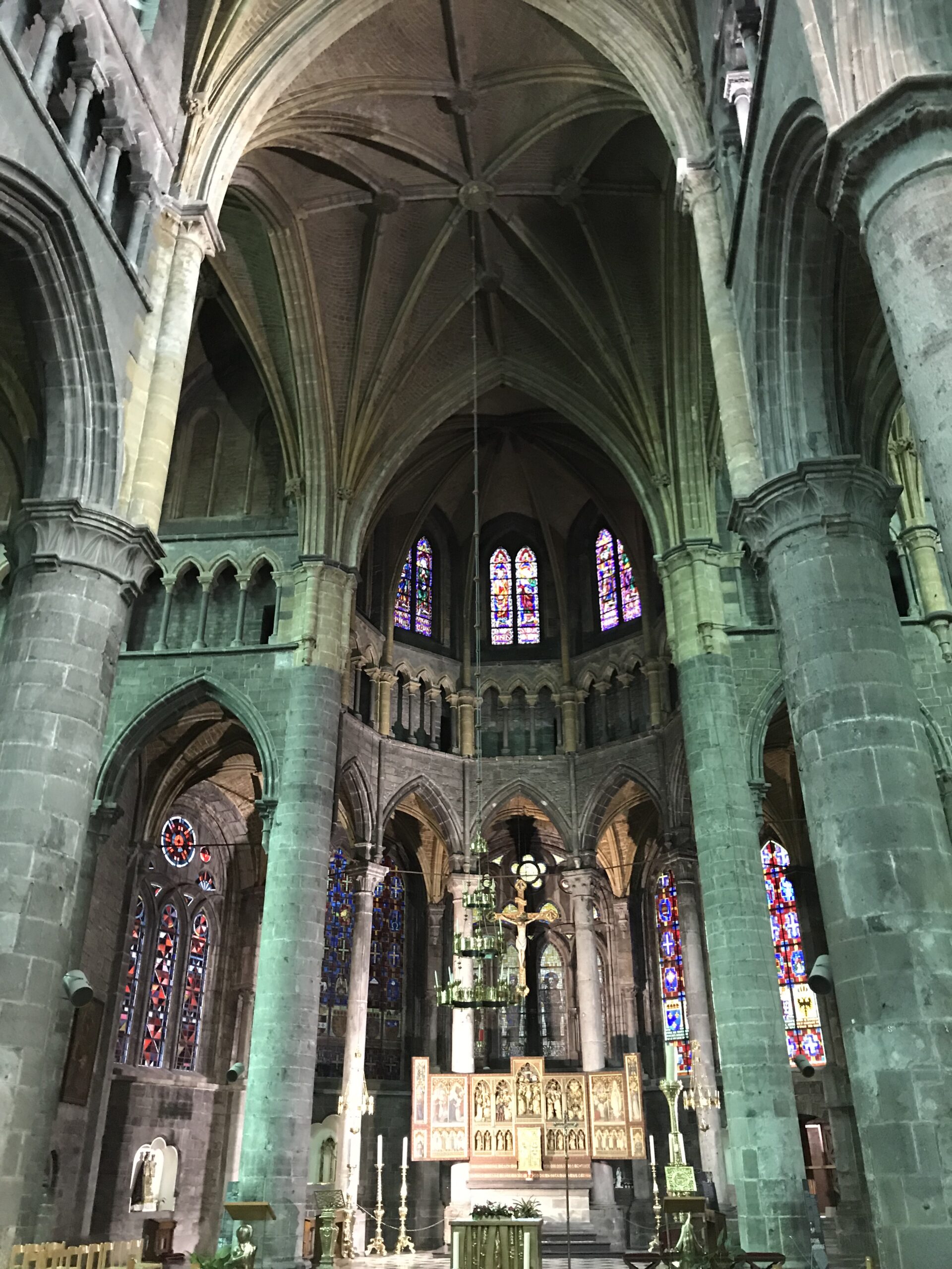 Wnętrze Collégiale Notre-Dame w Dinant Wnętrze Collégiale Notre-Dame w Dinant z gotyckimi sklepieniami, masywnymi filarami, witrażami, krucyfiksem i ołtarzem.