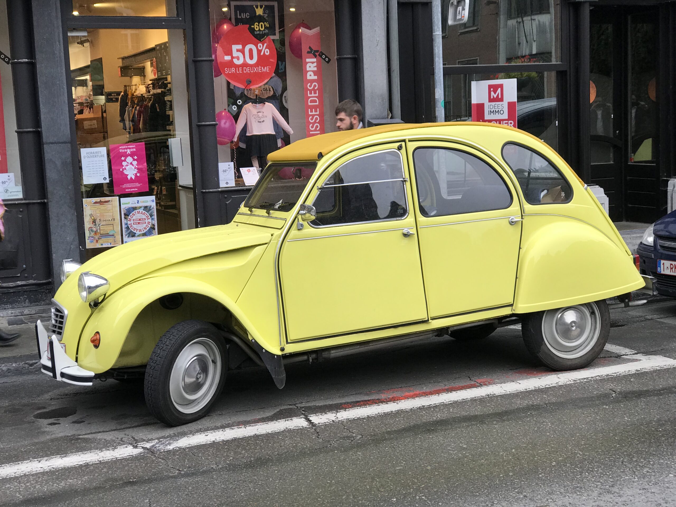 Żółty Citroën 2CV w Dinant Żółty Citroën 2CV zaparkowany przy ulicy w Dinant przed sklepem z wyprzedażą.