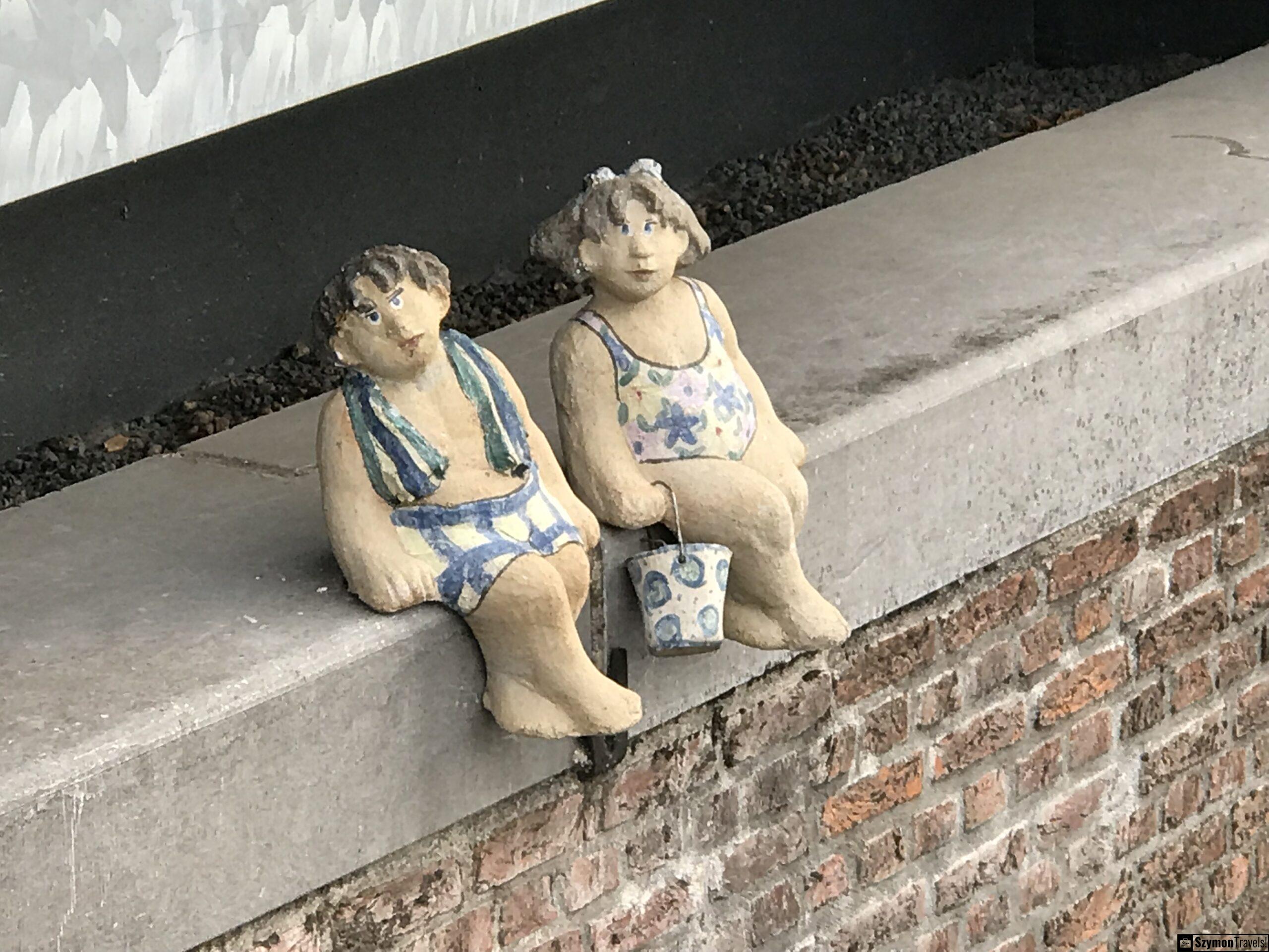 Zbliżenie na ceramiczne figurki w Dordrecht Zbliżenie na dwie ceramiczne figurki w strojach kąpielowych siedzące na murze w Dordrecht.