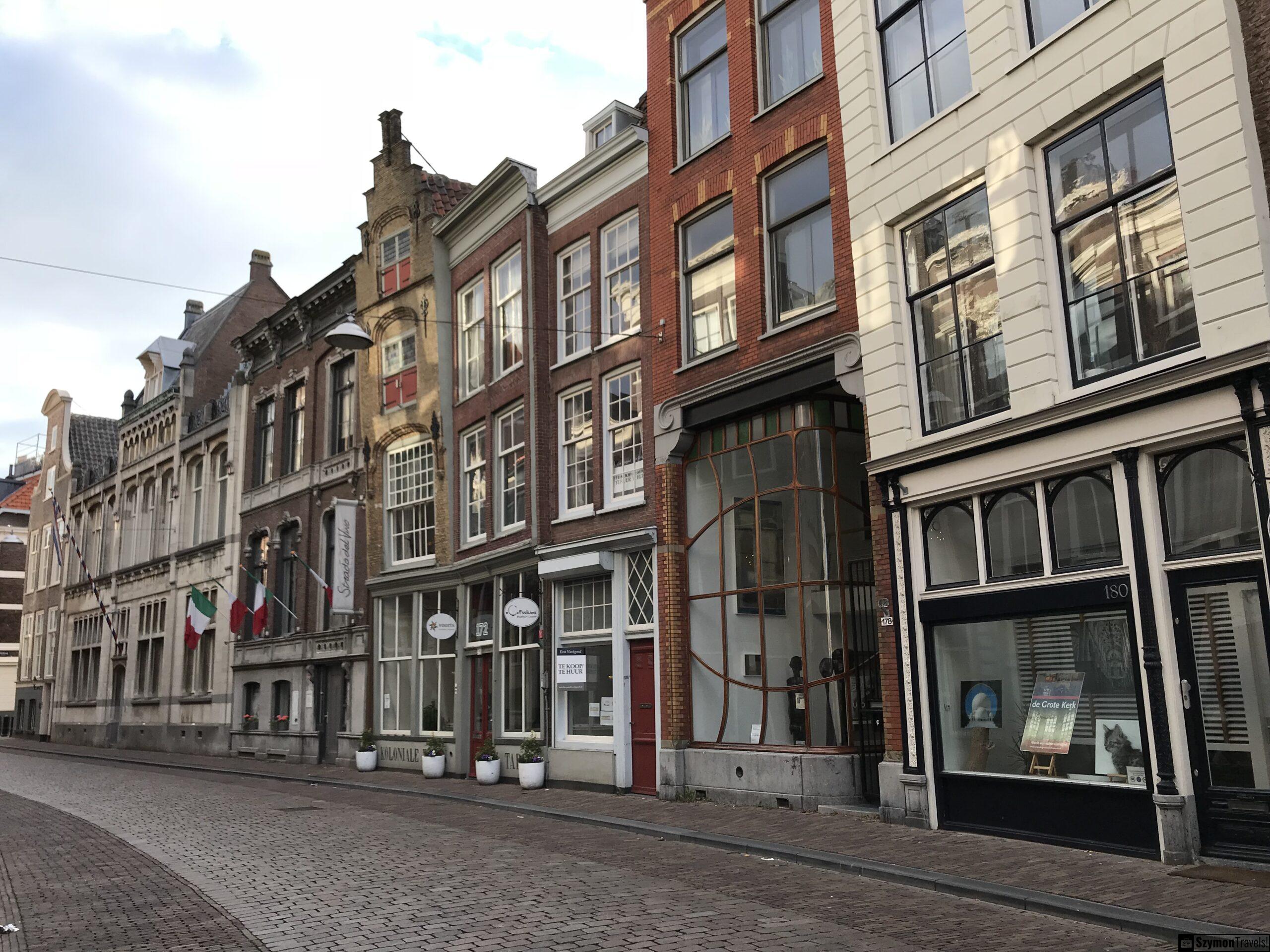 Historyczne fasady i restauracje w centrum Dordrecht Rząd historycznych fasad w centrum Dordrecht, z restauracją Strada del Vino, dużymi oknami, cegłą i eleganckimi parterami.