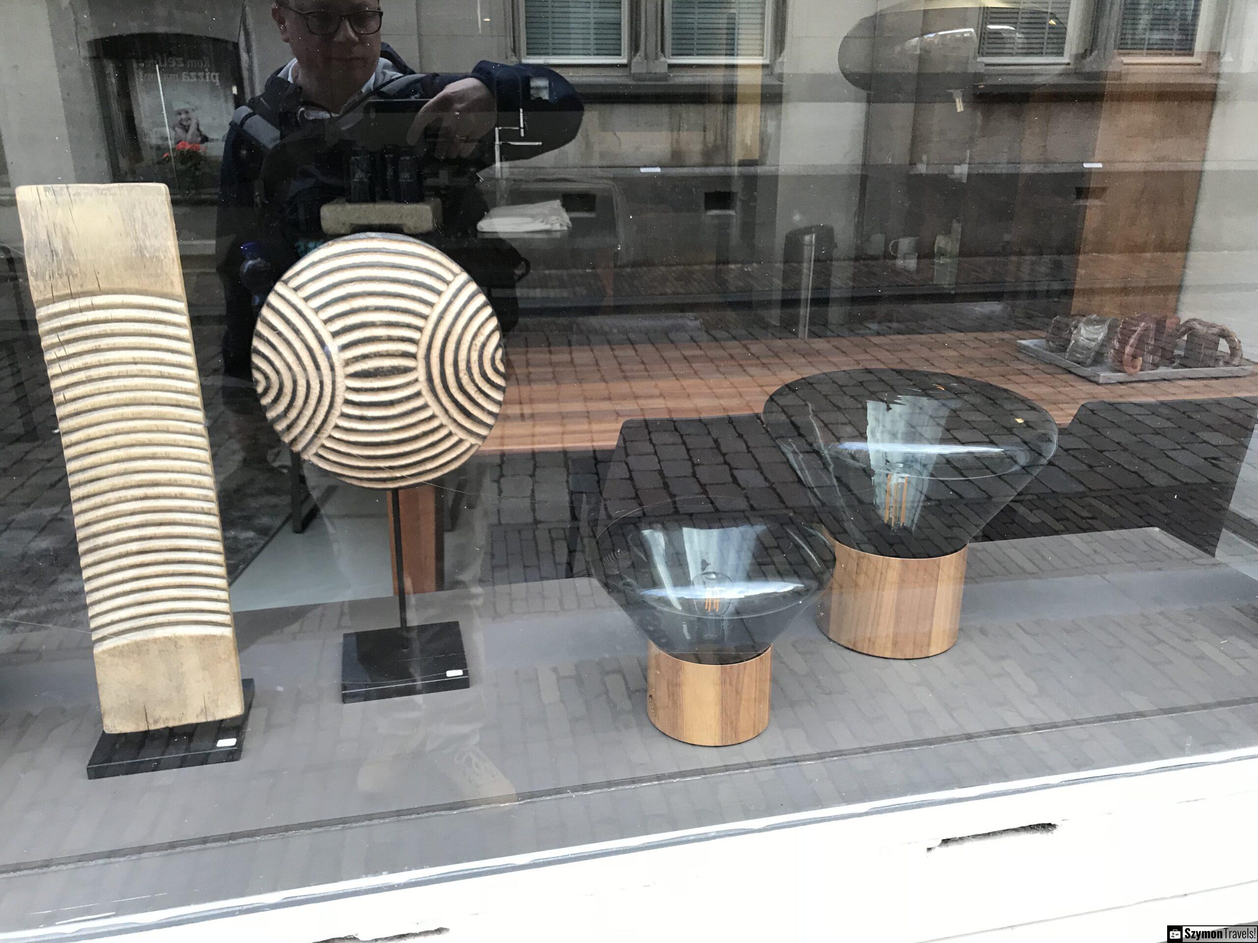 Witryna z designem i odbiciem autora w Dordrecht Witryna z designerskimi naczyniami i dekoracyjnymi przedmiotami w Dordrecht, z odbiciem autora fotografującego szybę oraz odbiciem brukowanej ulicy.