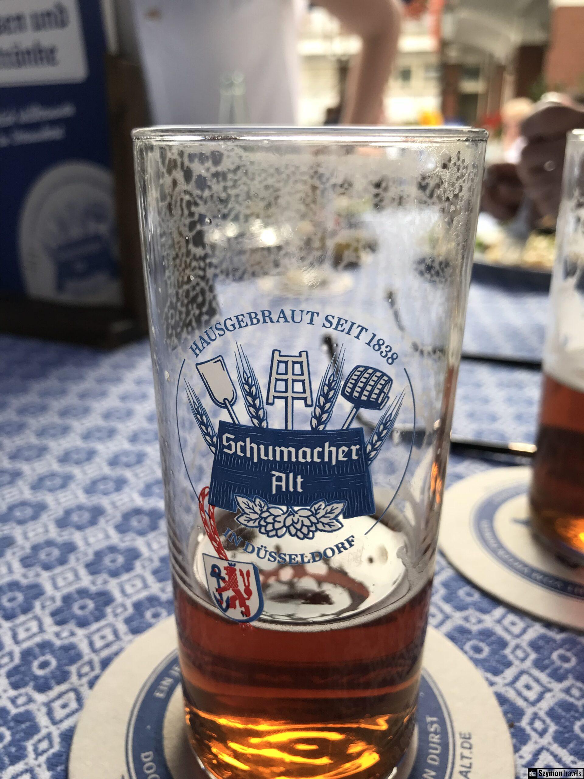 Schumacher Alt w szklance w Brauerei Schumacher Szklanka Schumacher Alt w Brauerei Schumacher w Düsseldorfie na tle stołu restauracyjnego