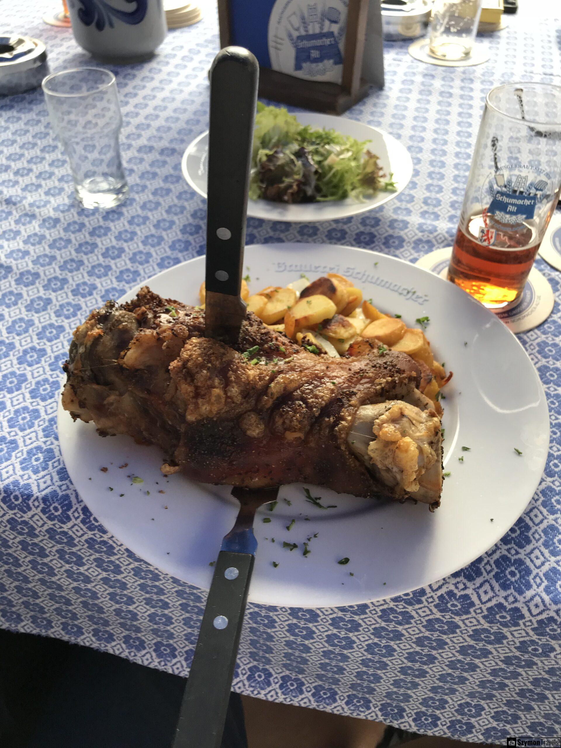 Pieczona golonka i Altbier w Brauerei Schumacher Pieczona golonka w Brauerei Schumacher w Düsseldorfie podana z ziemniakami i szklanką Altbier