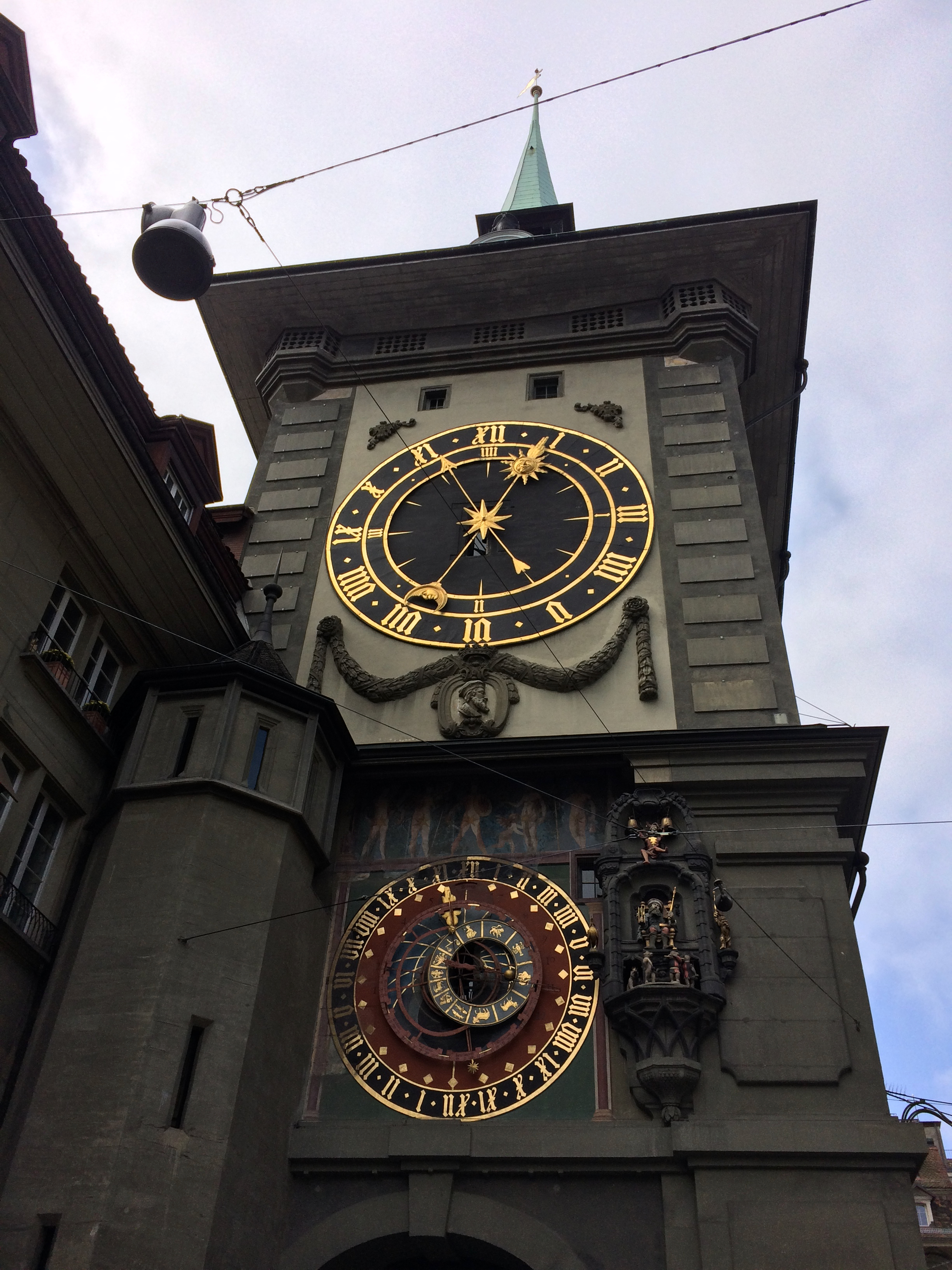 Zytglogge w Bernie z dużą tarczą zegarową i zegarem astronomicznym, widziany od dołu.