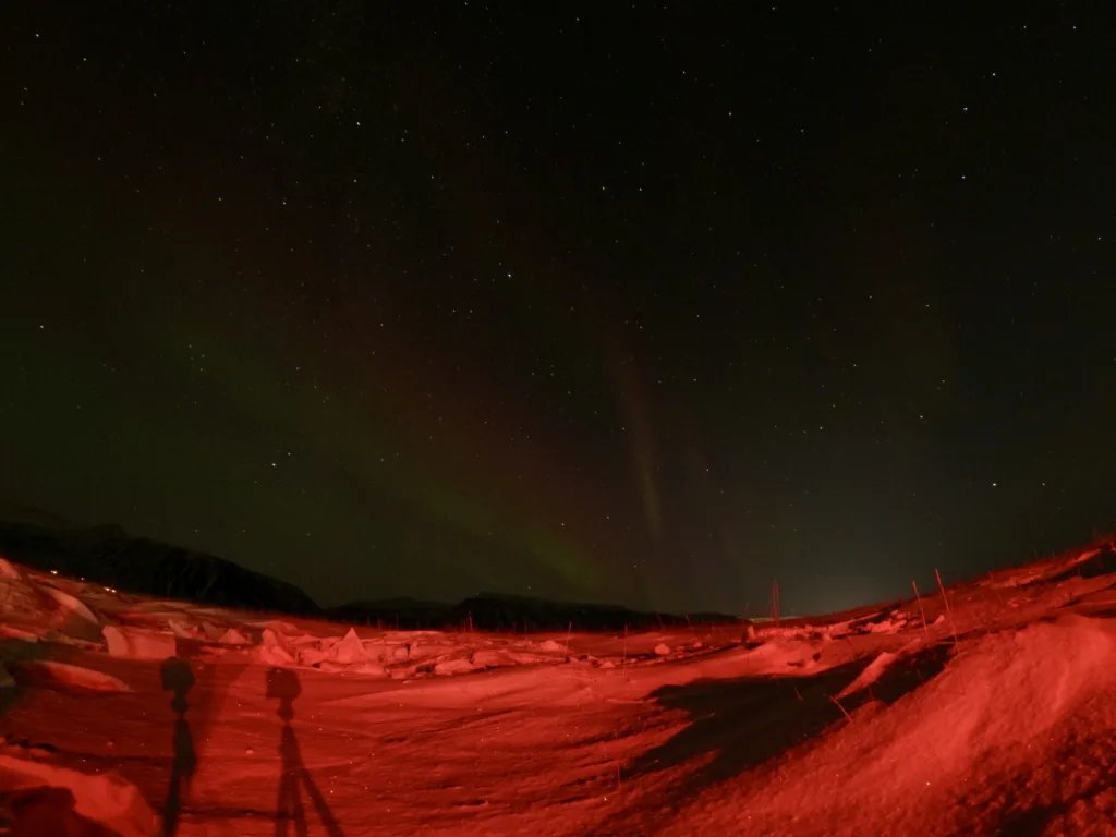 An icy wasteland illuminated by the lights of a snow cat