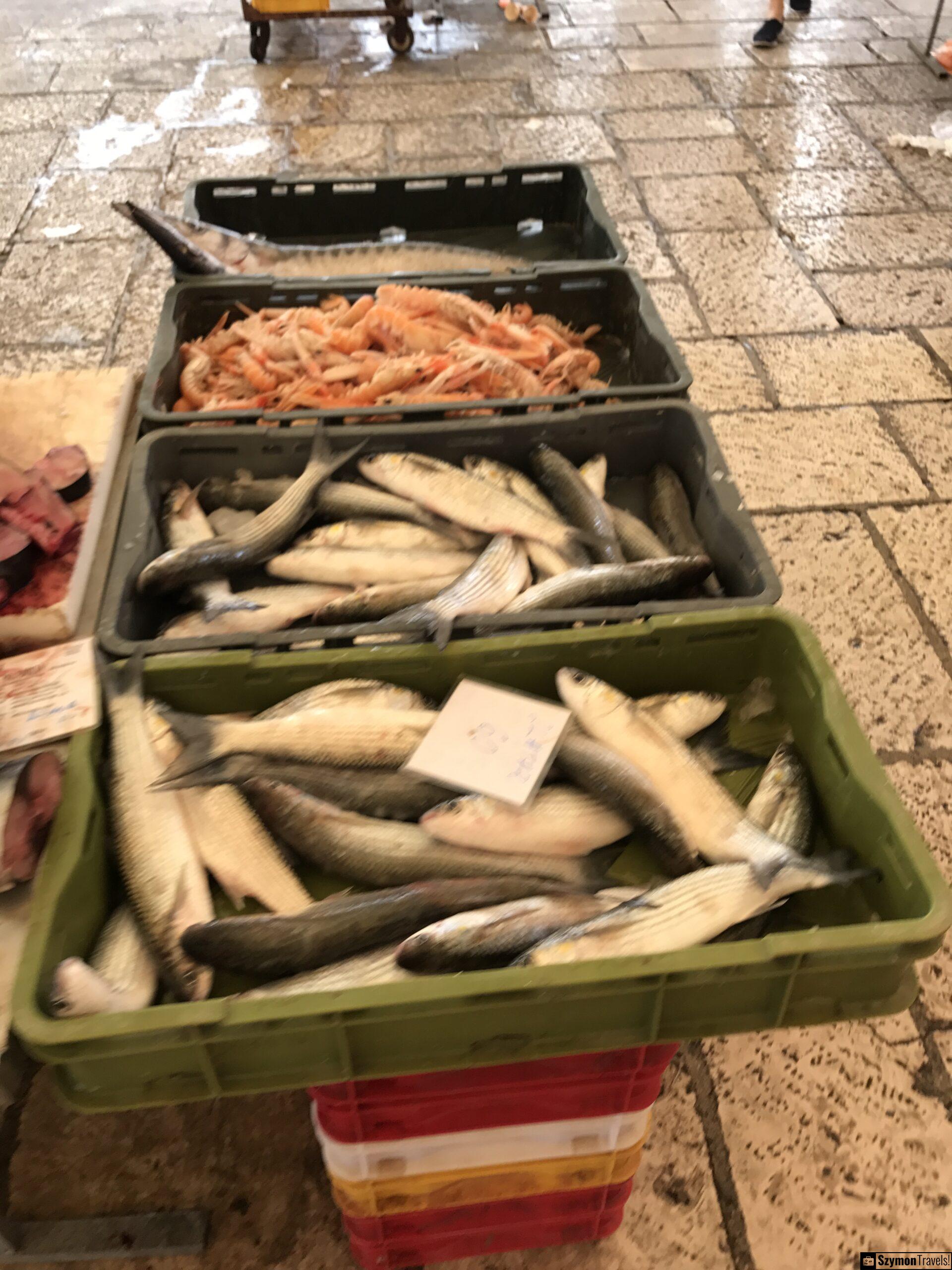Skrzynki z rybami na targu w Splicie Skrzynki z rybami i krewetkami na mokrej kamiennej posadzce targu rybnego w Splicie.