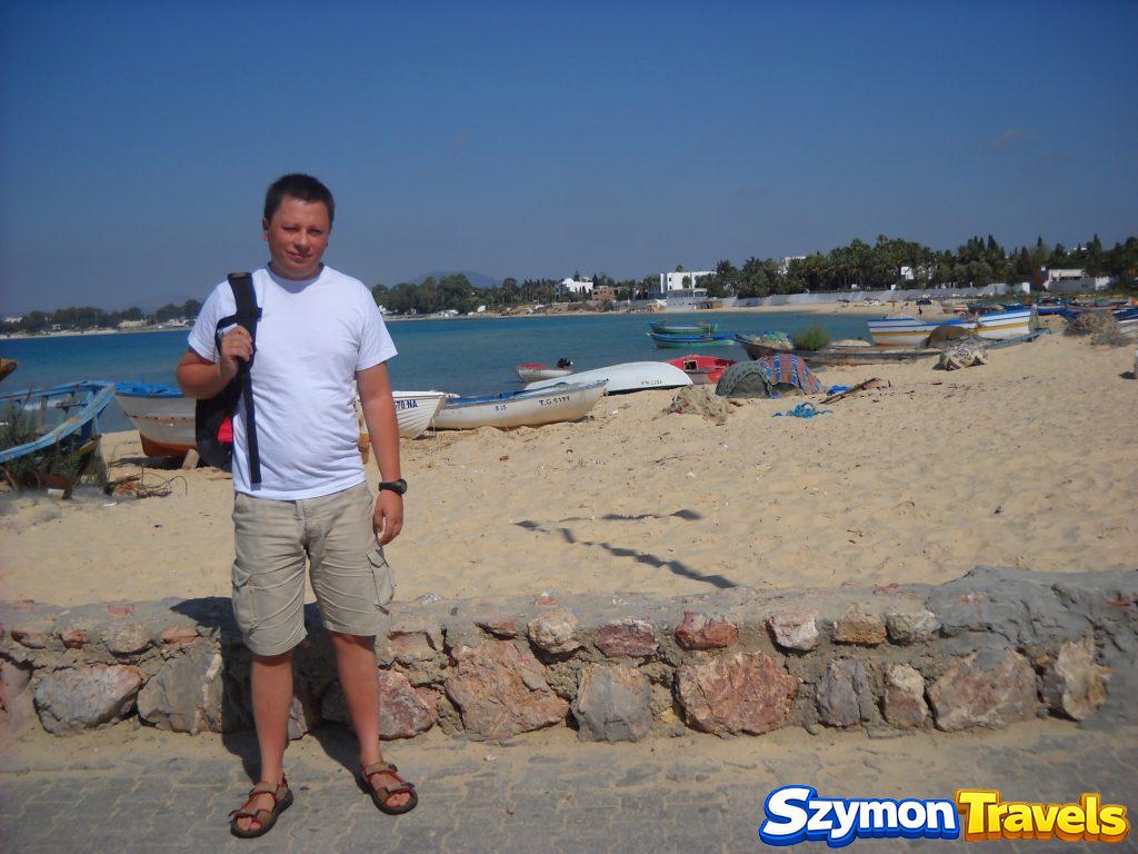 Szymon na plaży w Hammamecie z łodziami rybackimi i turkusowym morzem