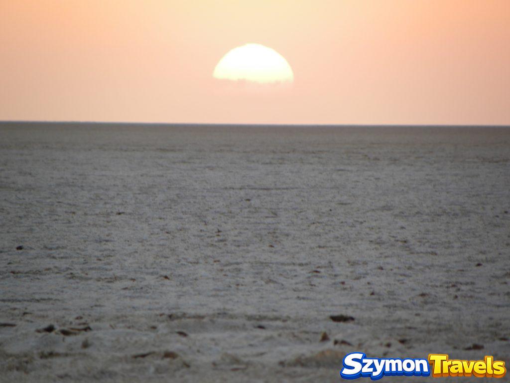 Słońce wschodzące nad horyzontem słonego jeziora Chott el-Jerid w Tunezji