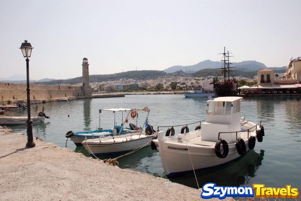 Stary port w Rethymno z łodziami, latarnią morską i wzgórzami w tle