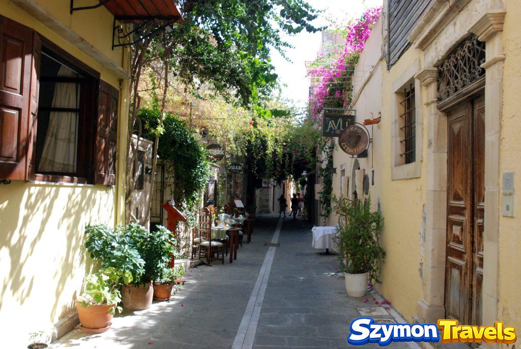 Kolorowa uliczka w starym mieście Rethymno z roślinami, drewnianymi drzwiami i restauracją