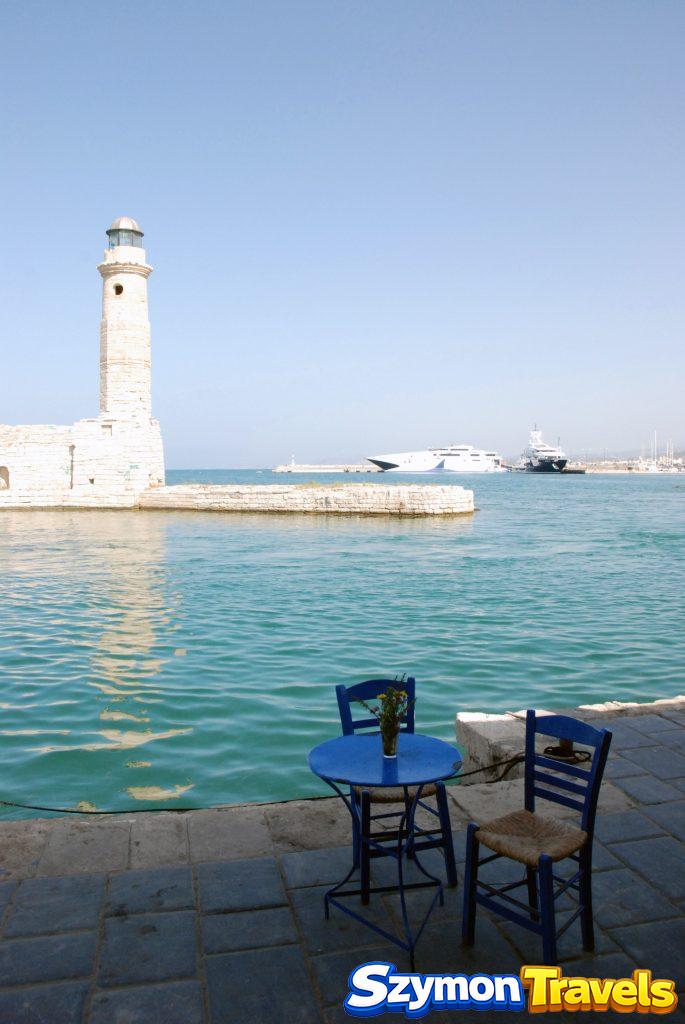 Wenecka latarnia morska w starym porcie w Rethymno na Krecie widziana z kawiarni przy wodzie