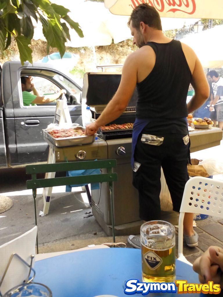Kucharz grillujący souvlaki przy ulicznym lokalu w Chanii na Krecie