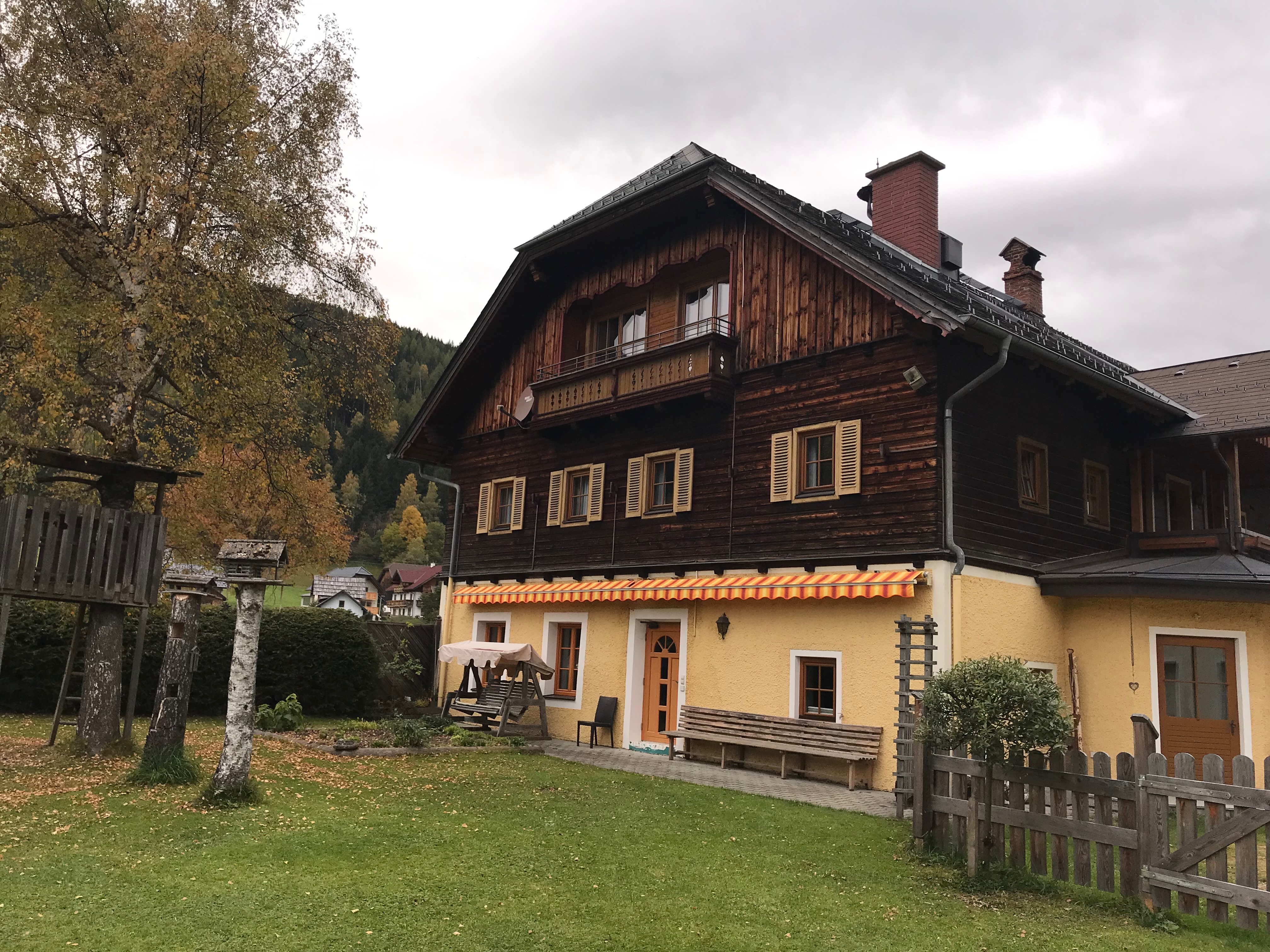 Główny budynek Gut Neusess w Mauterndorf z drewnianą fasadą, balkonem i ogrodem