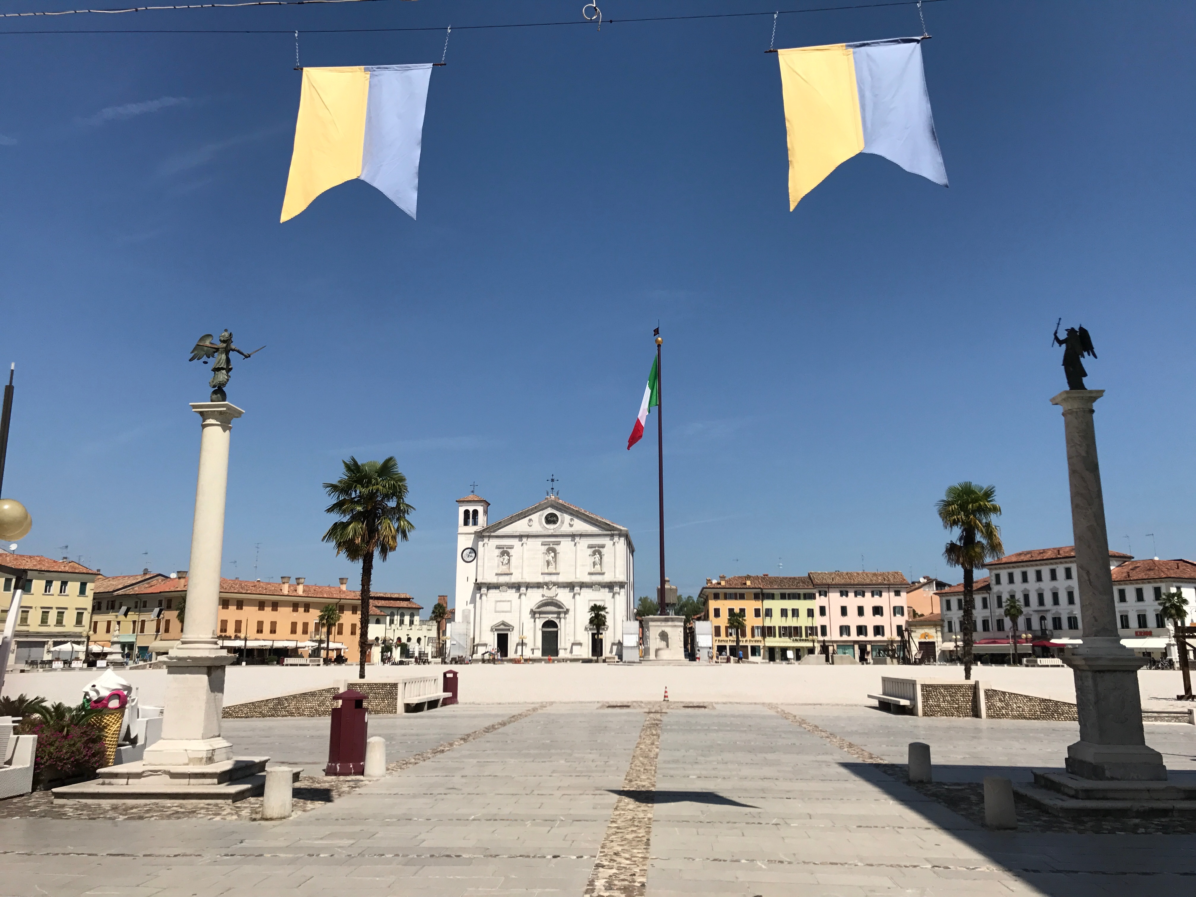 Piazza Grande w Palmanovie z Duomo Dogale, włoską flagą i dwiema kolumnami z posągami