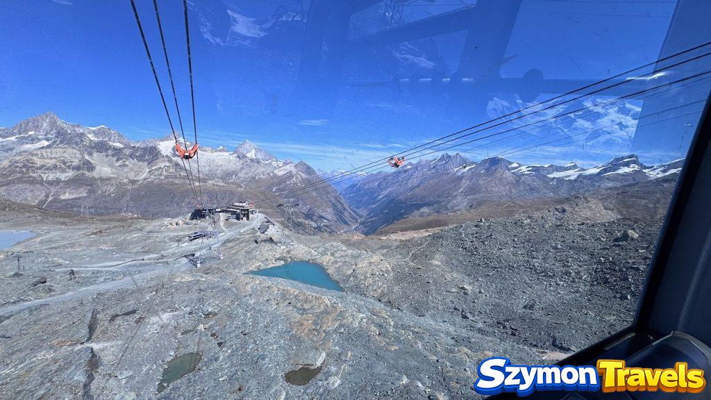 Widok z kolejki na lodowiec pod Matterhorn Glacier Paradise Widok z gondoli na lodowcowy krajobraz pod Matterhorn Glacier Paradise, z linami kolejki, skalistym terenem i turkusowym jeziorkiem.