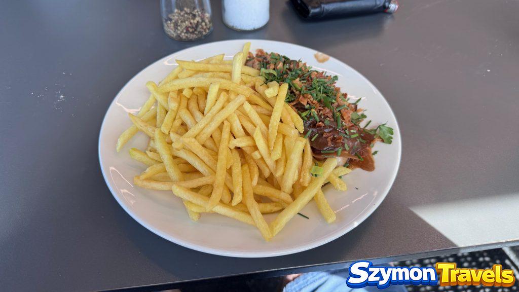 Obiad na górze w rejonie Matterhorn Glacier Paradise Talerz frytek z mięsnym sosem i ziołami podany w restauracji górskiej w rejonie Matterhorn Glacier Paradise.