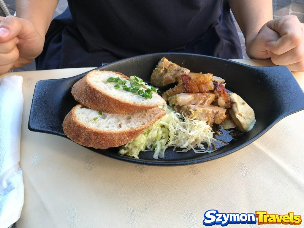 Tyrolskie danie mięsne z pieczywem w Innsbrucku Tyrolskie danie mięsne podane z pieczywem, kapustą i chrzanem na czarnym półmisku w restauracji w Innsbrucku.