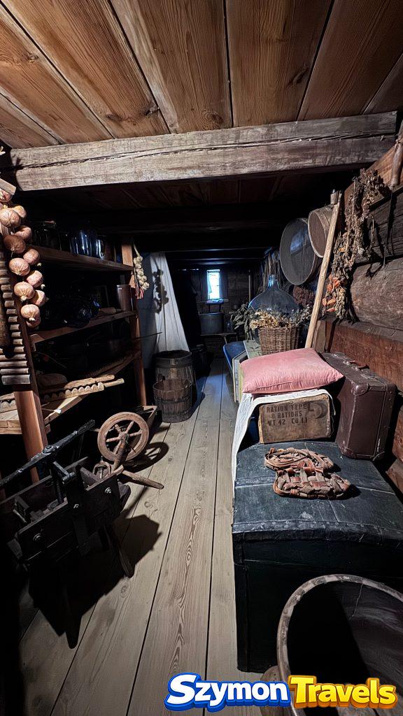 Ciemne pomieszczenie gospodarcze z narzędziami, skrzyniami i zapasami w Muzeum Wsi Opolskiej