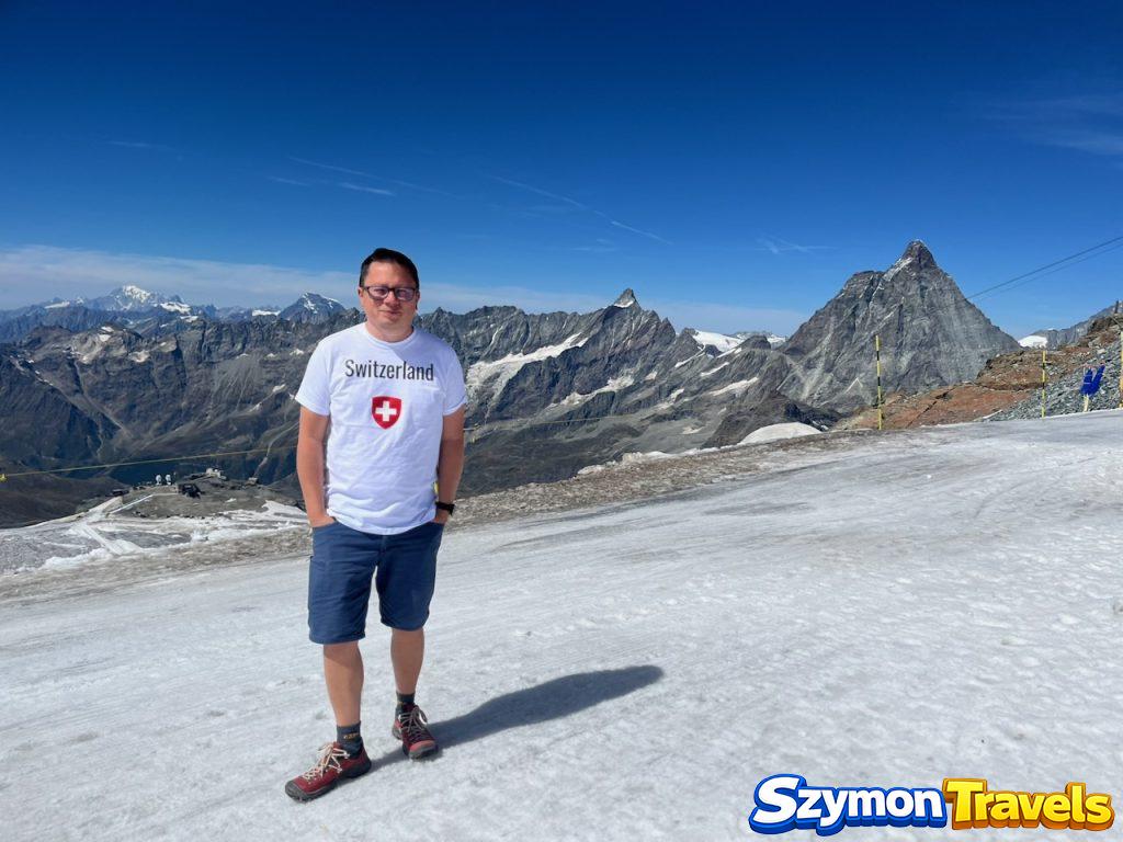 Szymon na Matterhorn Glacier Paradise z Matterhornem w tle Szymon stojący na śniegu na Matterhorn Glacier Paradise, z Matterhornem i alpejskimi szczytami w tle.