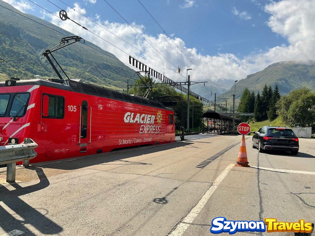 Czerwona lokomotywa Glacier Express obok stanowiska Autoverlad Furka