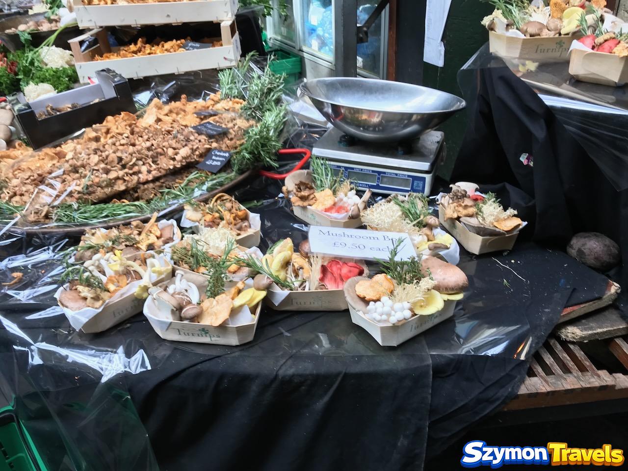 Koszyki z różnymi gatunkami świeżych grzybów na Borough Market w Londynie