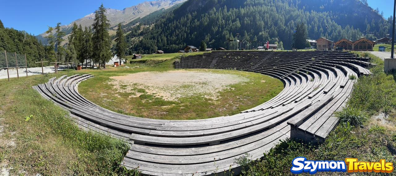 Hérens Arena w Les Haudères z drewnianymi trybunami i górami w tle