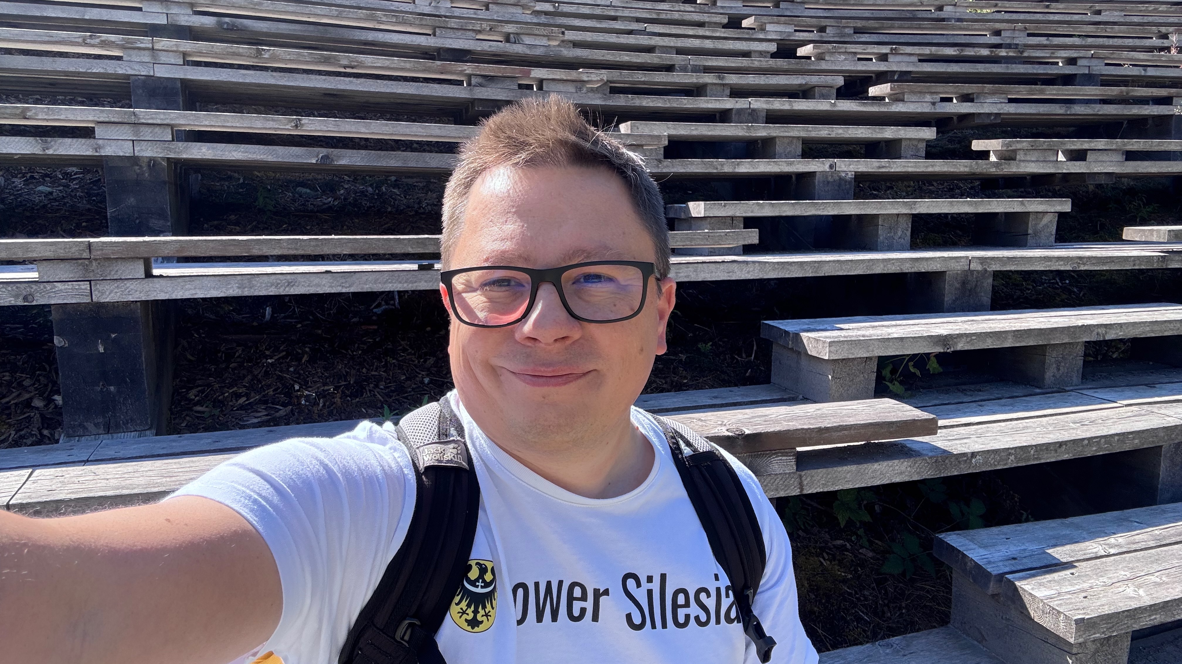 Szymon na tle drewnianych trybun Hérens Arena w Les Haudères