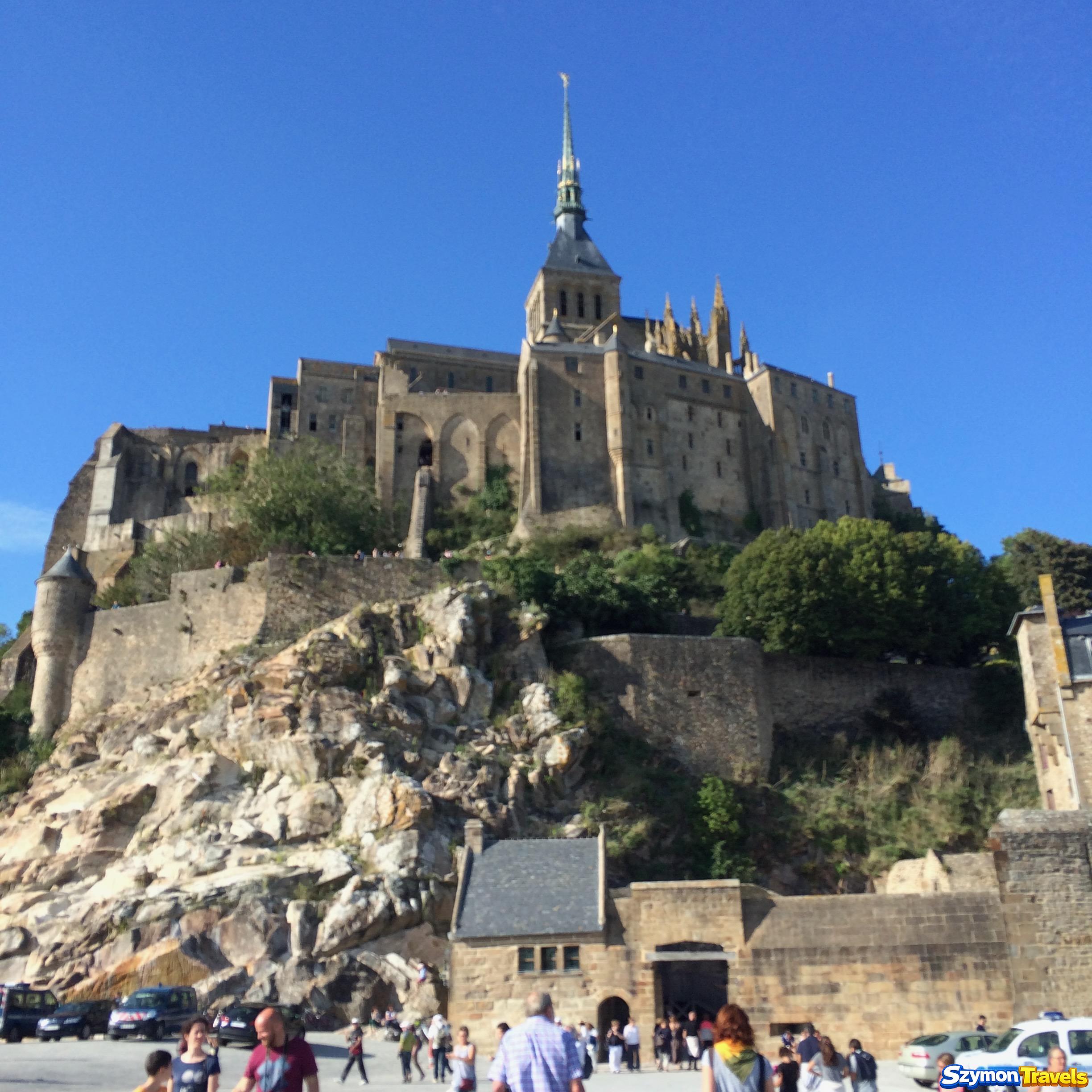 Opactwo Mont-Saint-Michel widziane z bliska ponad skałami i murami wejściowymi