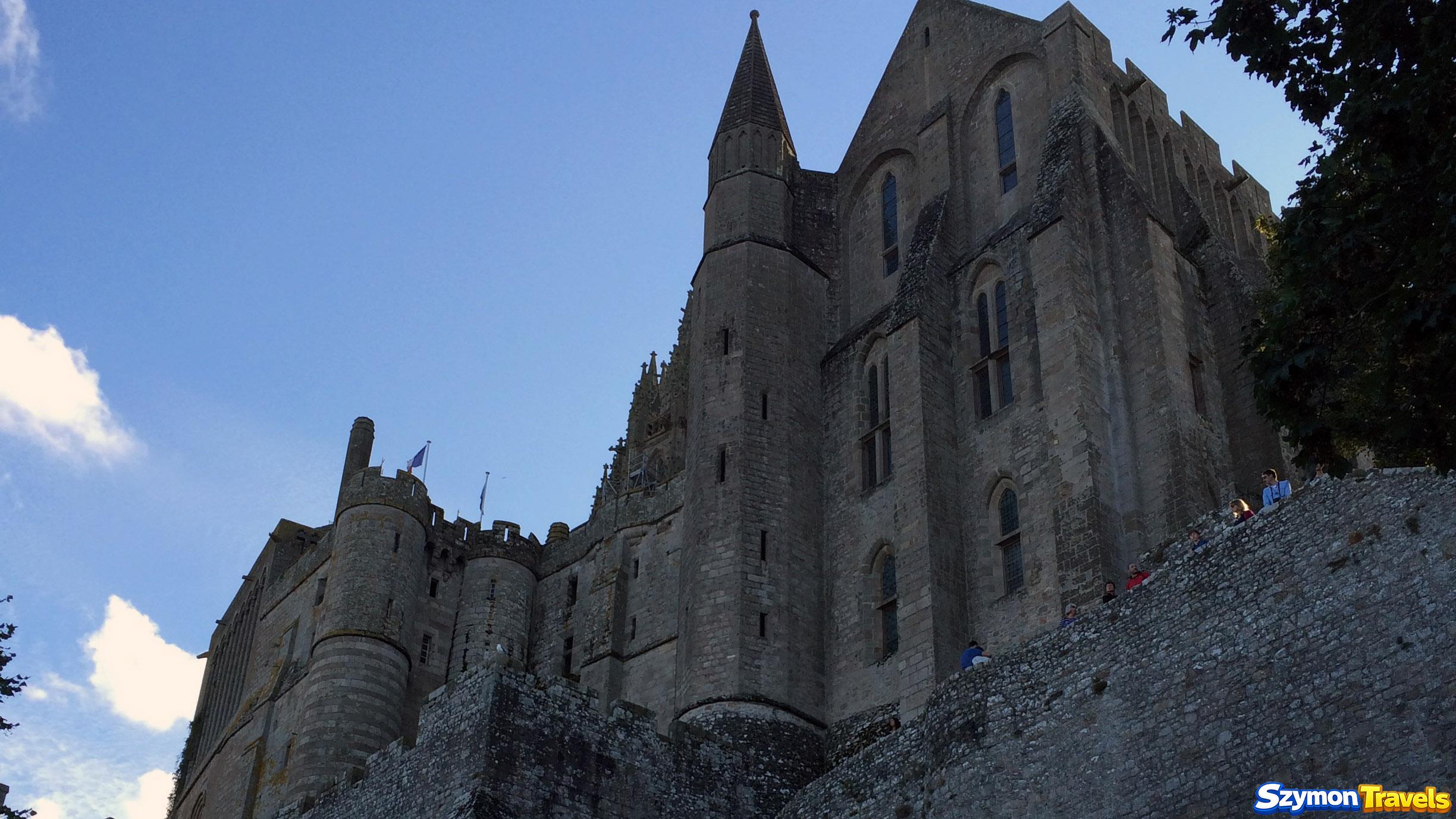 Monumentalne kamienne zabudowania opactwa Mont-Saint-Michel widziane od dołu