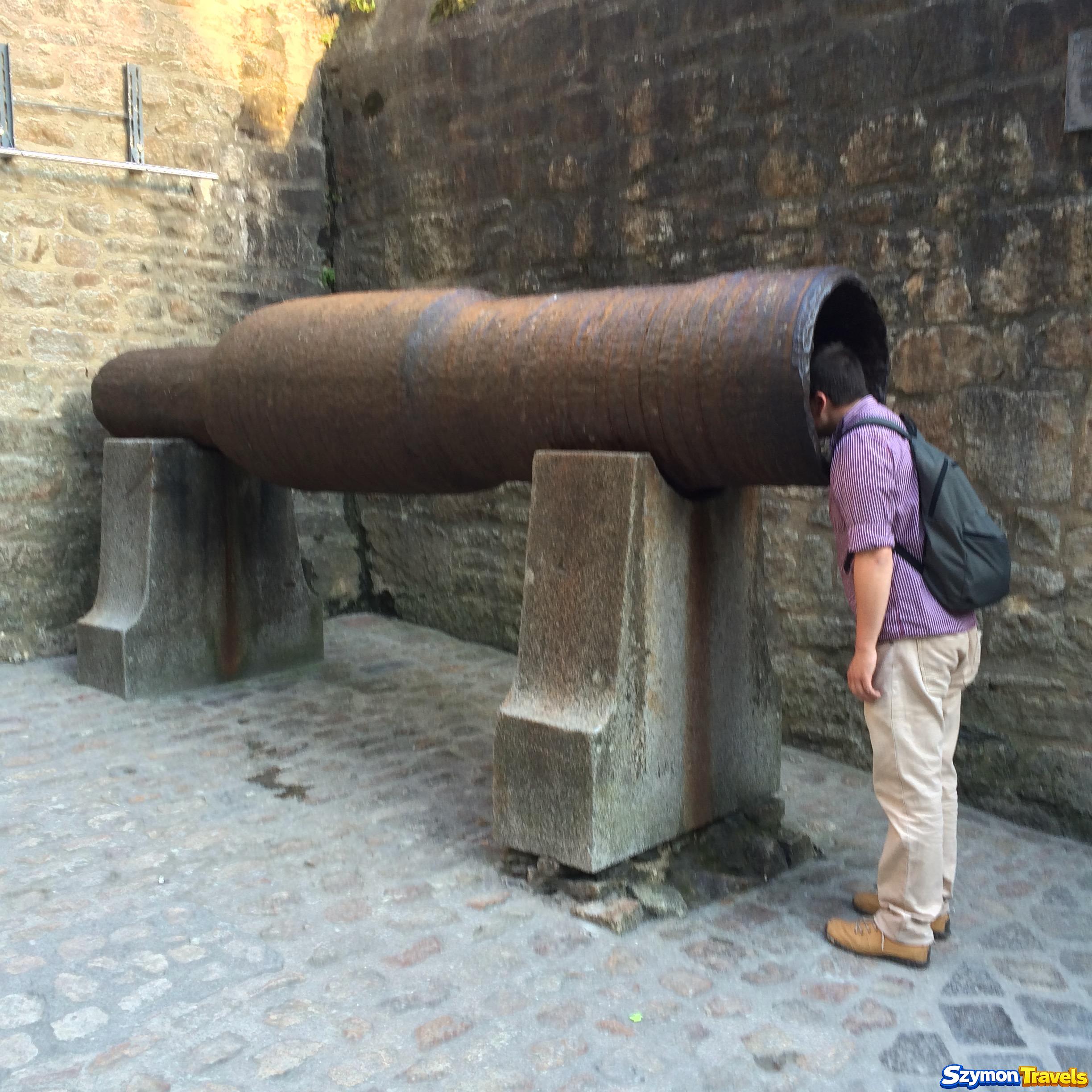 Szymon zaglądający do wnętrza ogromnej angielskiej bombardy na Mont-Saint-Michel