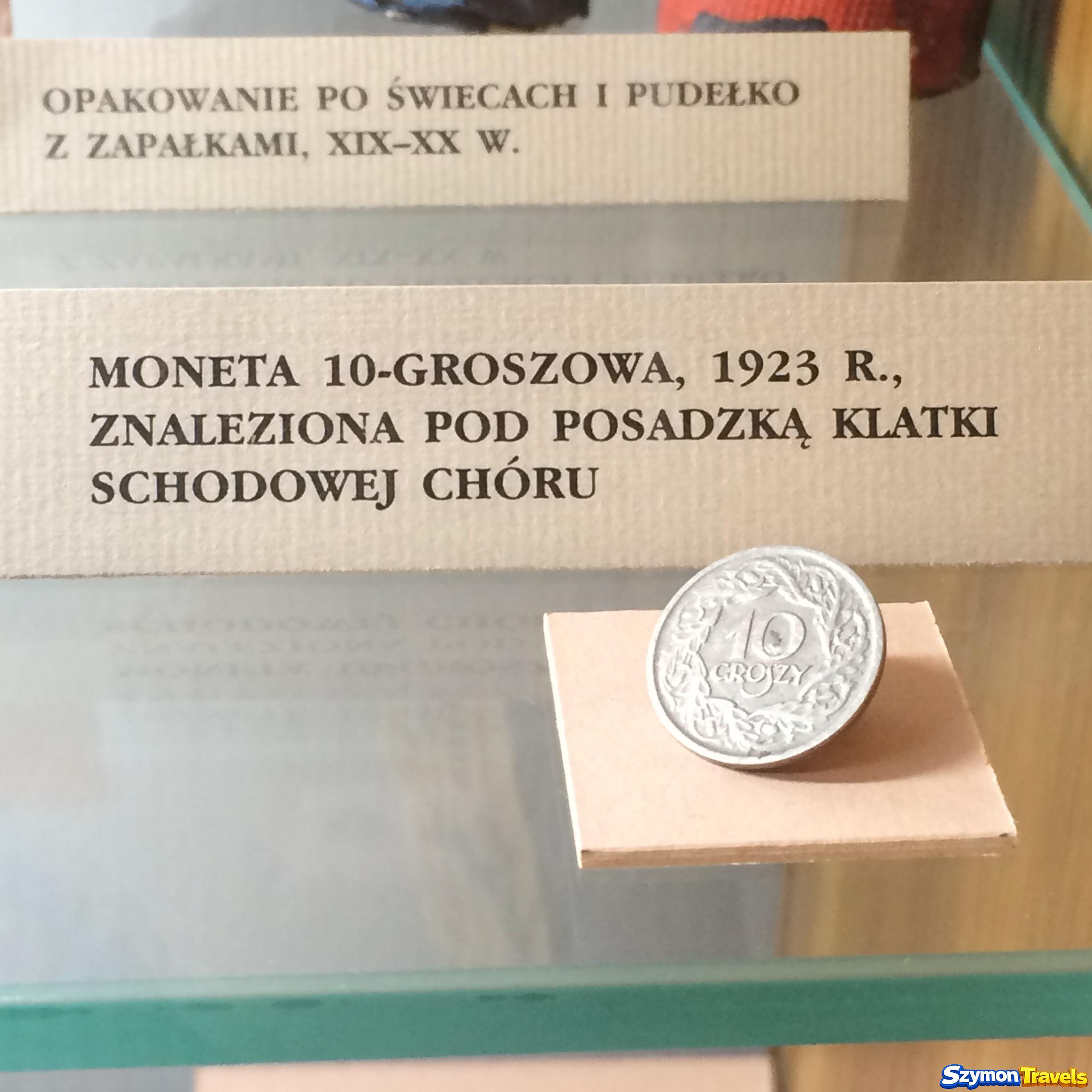 Opakowanie po świecach, pudełko z zapałkami oraz moneta dziesięciogroszowa z 1923 roku znaleziona pod posadzką klatki schodowej chóru