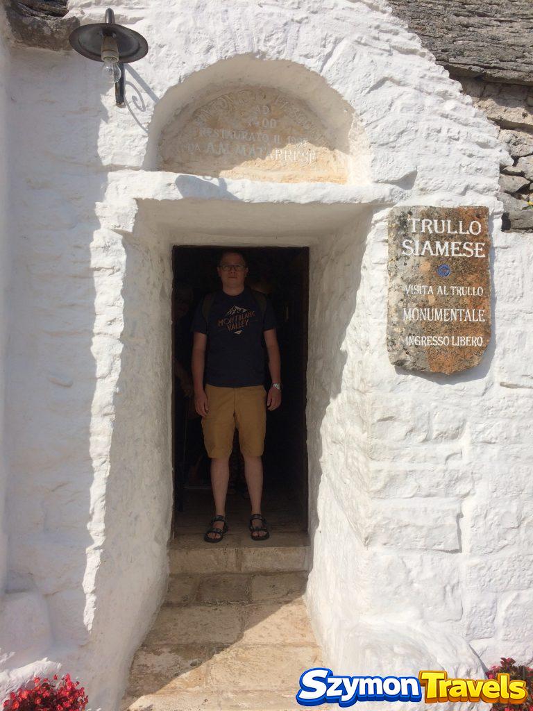 Szymon stojący w wejściu do Trullo Siamese podczas wizyty w Alberobello w 2016 roku