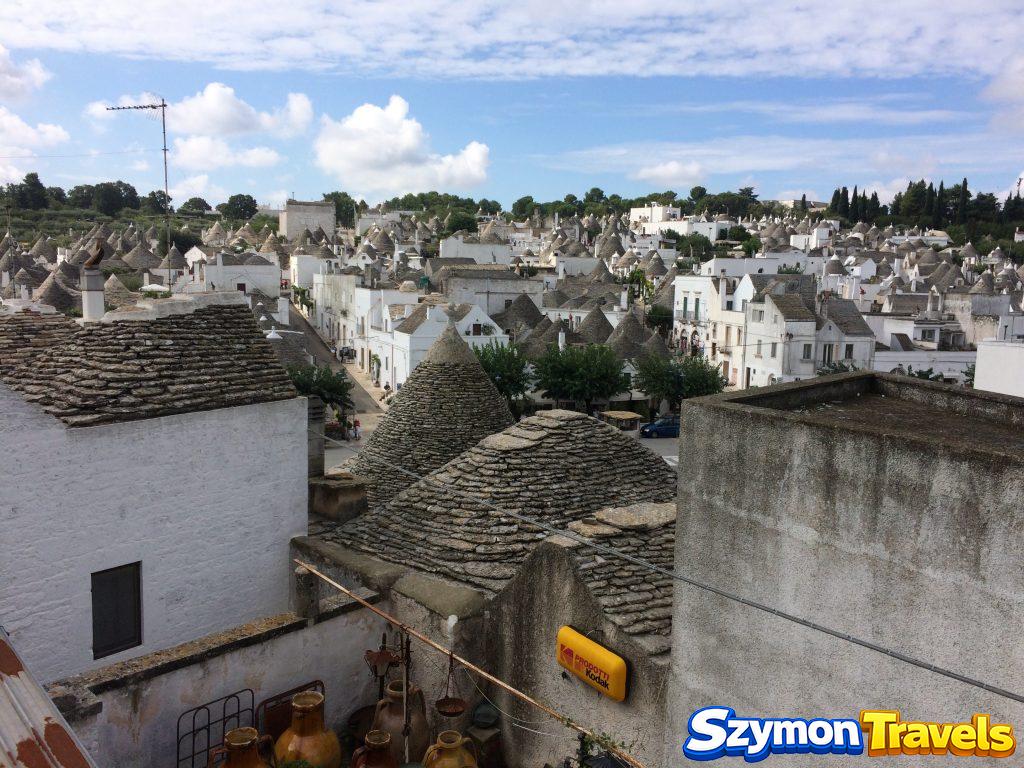Panorama Alberobello z setkami białych domów trulli i stożkowymi kamiennymi dachami w dzielnicy Rione Monti