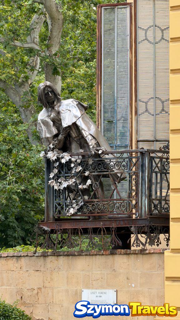 Rzeźba na balkonie w centrum Pécsu z tabliczką Liszt Ferenc