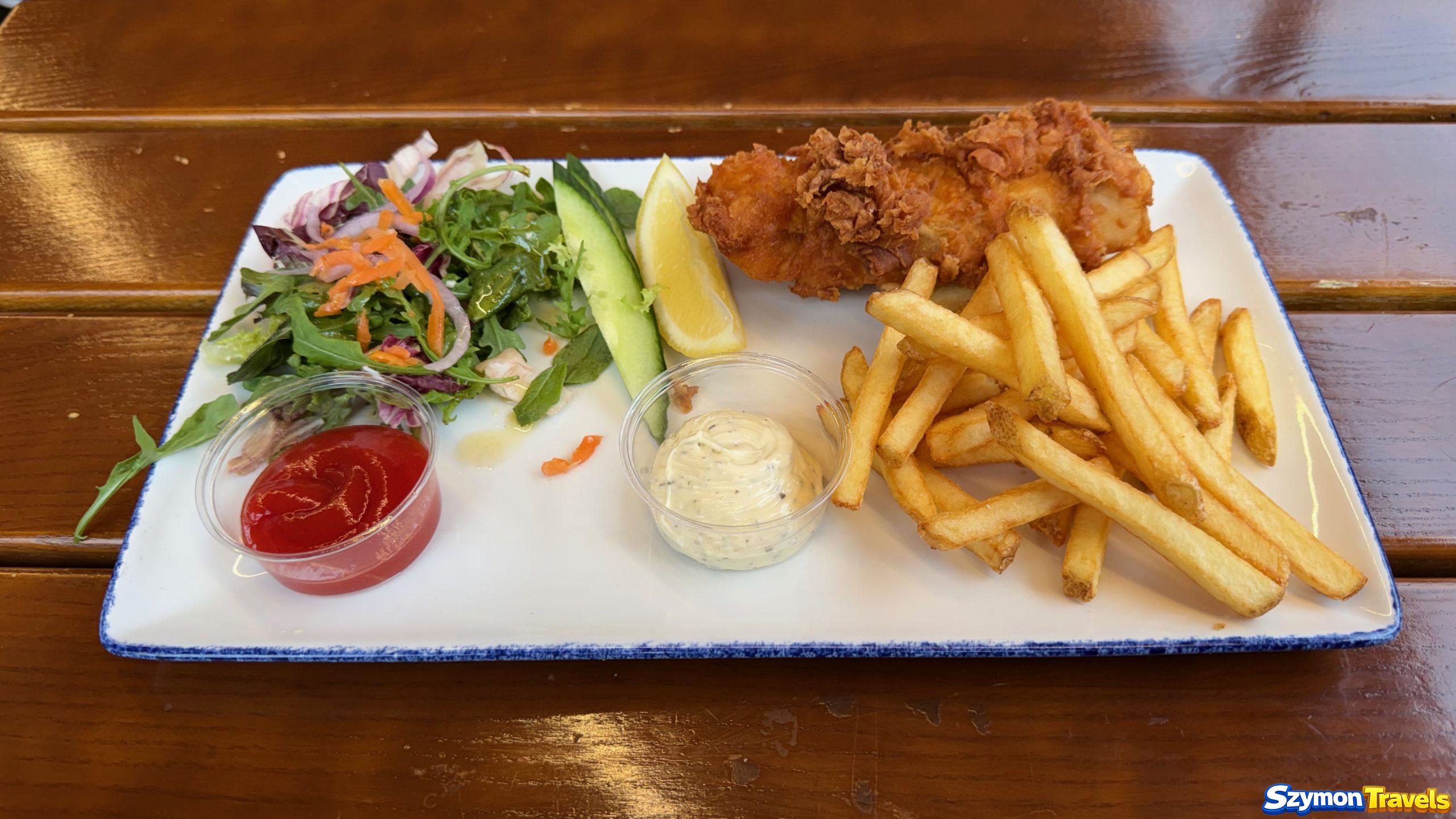 Fish and chips na targu rybnym w Bergen Porcja fish and chips z frytkami, sałatą i sosami w porcie w Bergen