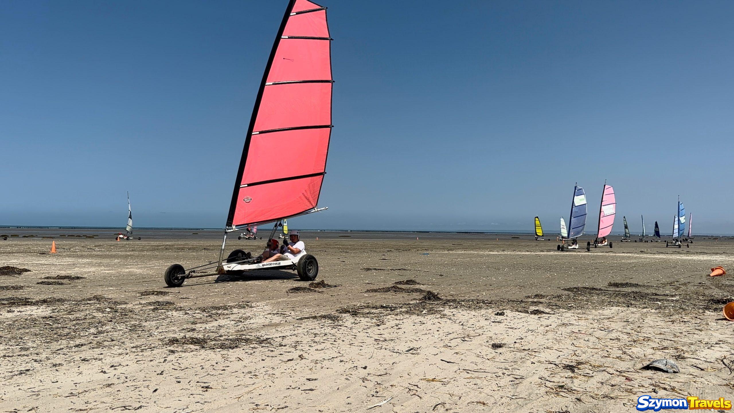 Szybka jazda char à voile Dwuosobowy char à voile z czerwonym żaglem podczas szybkiej jazdy w Hirel