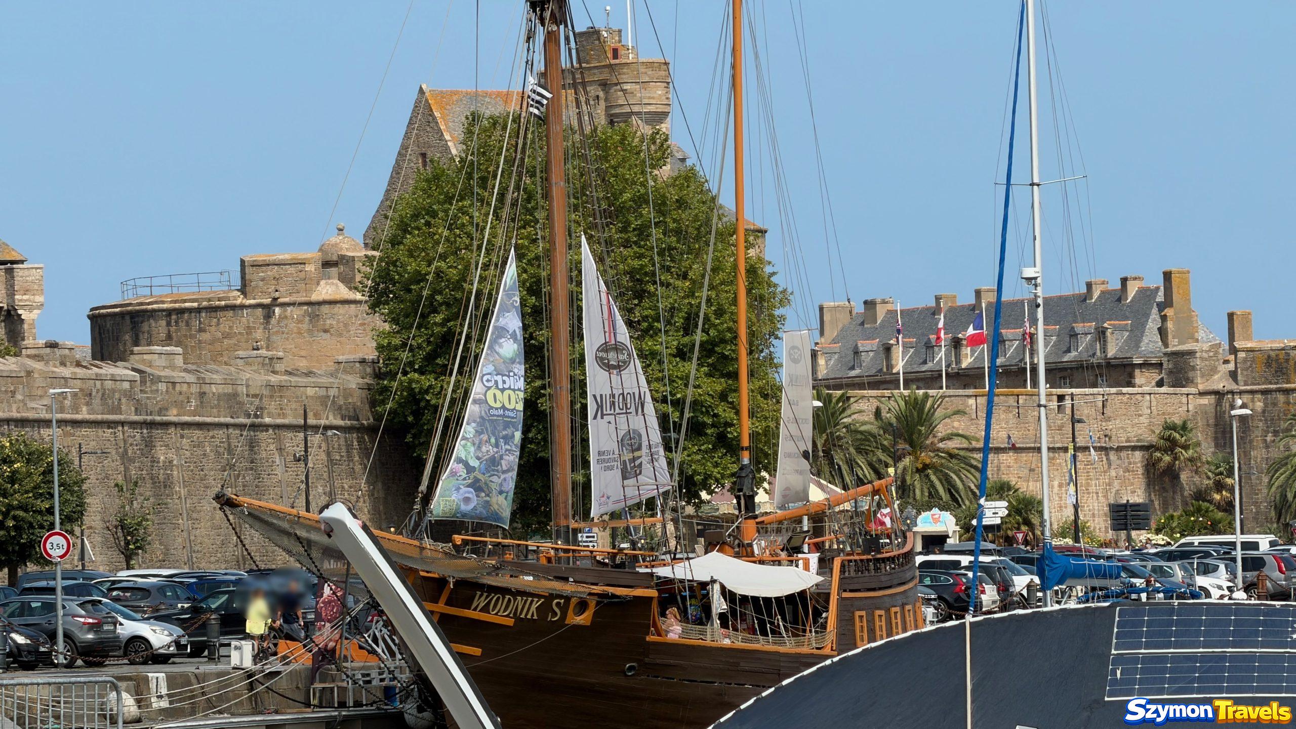 Parking przy murach i porcie Saint-Malo z żaglowcem Wodnik