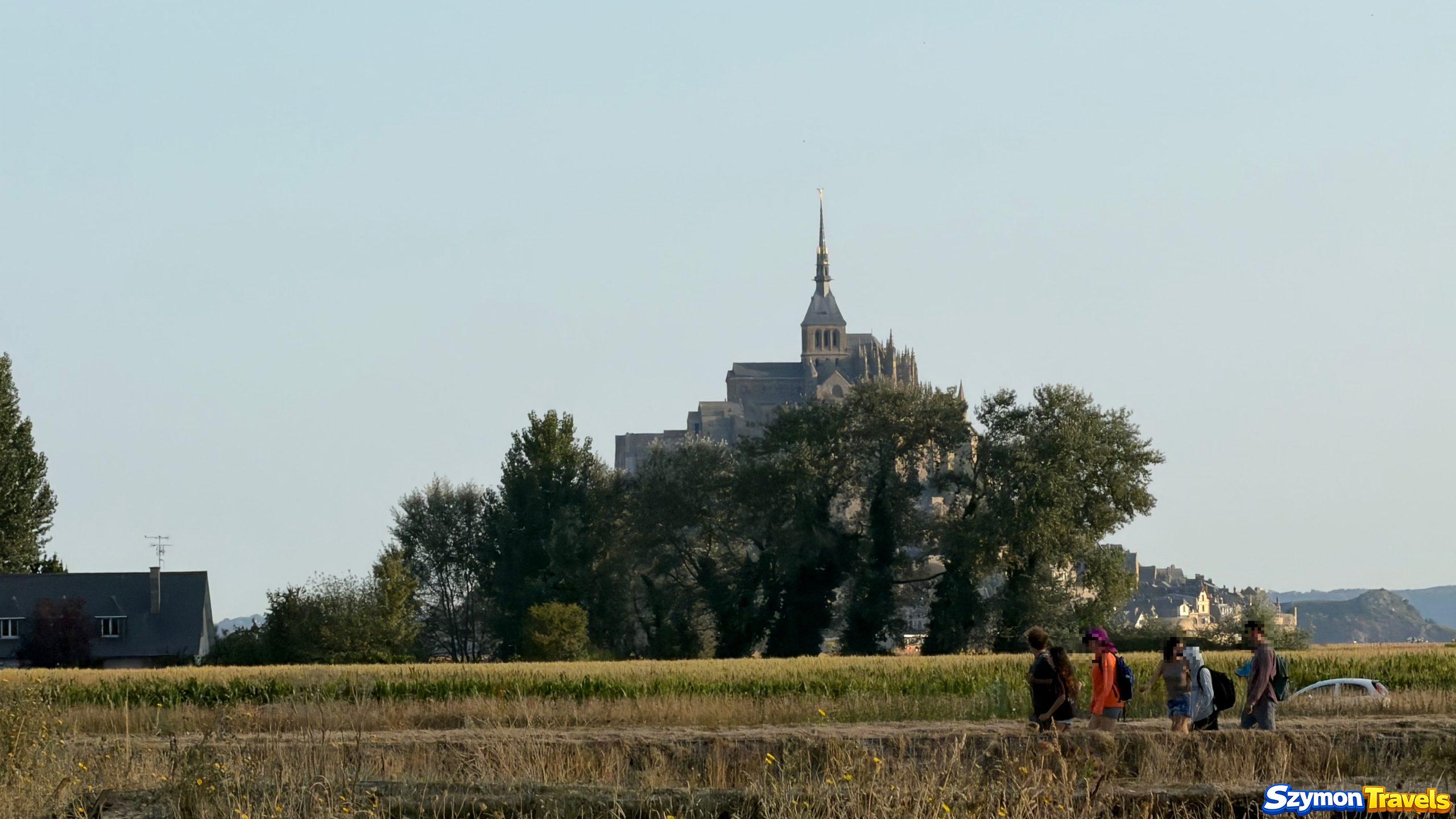 Mont-Saint-Michel z oddali Pierwszy widok Mont-Saint-Michel pomiędzy drzewami podczas spaceru