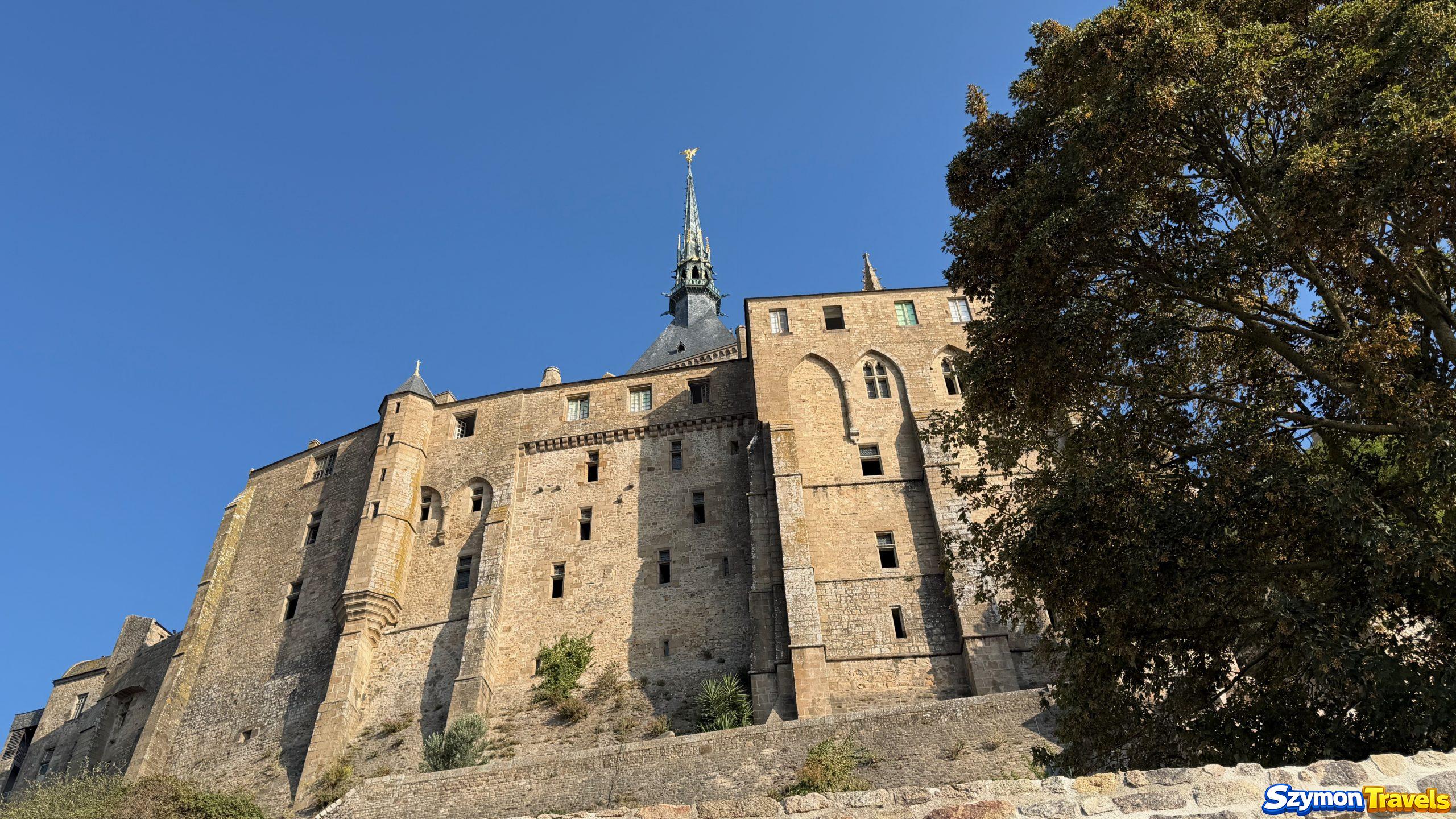 Pionowa architektura Mont-Saint-Michel Potężne kamienne ściany i przypory opactwa Mont-Saint-Michel widziane od dołu