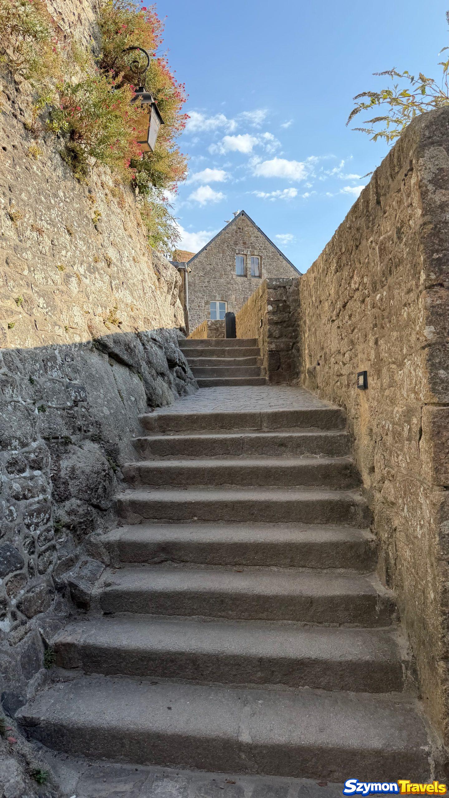 Zwiedzanie Mont-Saint-Michel bocznymi przejściami Kamienne schody prowadzące przez spokojniejsze fragmenty Mont-Saint-Michel