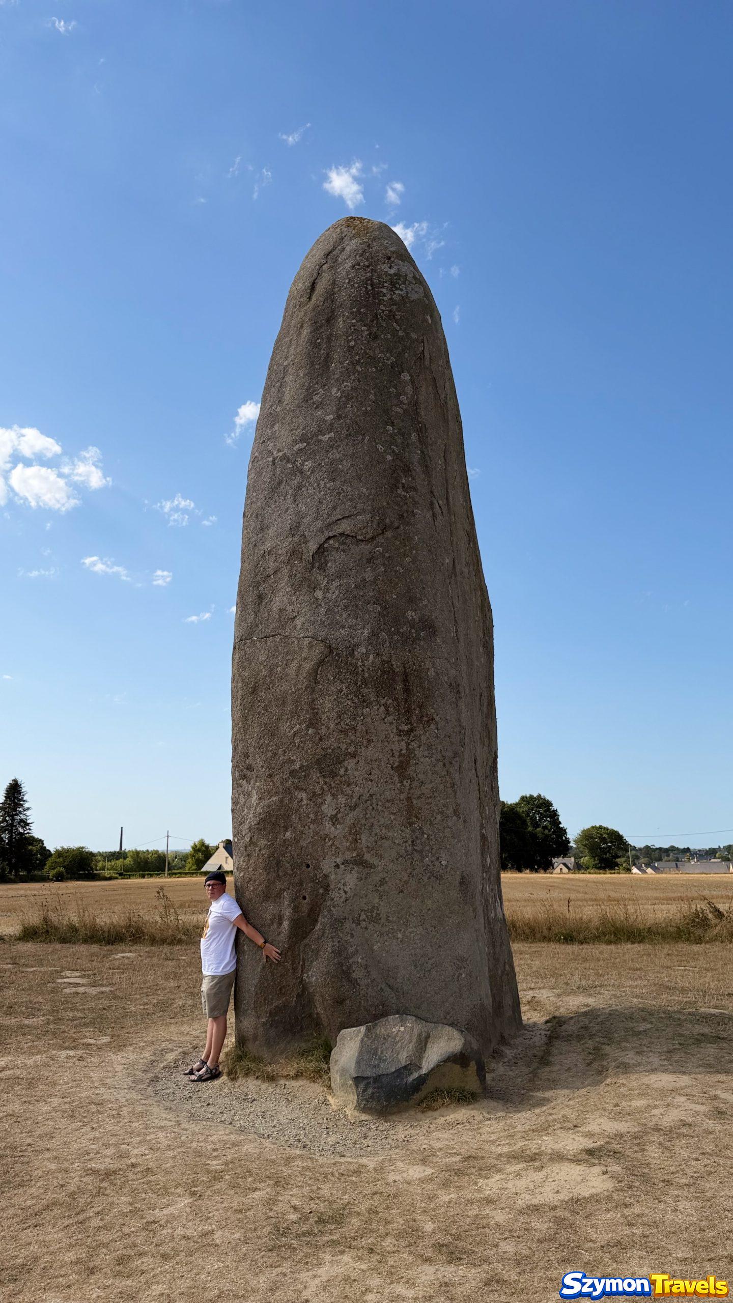 Menhir du Champ-Dolent w Dol-de-Bretagne – człowiek pokazuje skalę monolitu