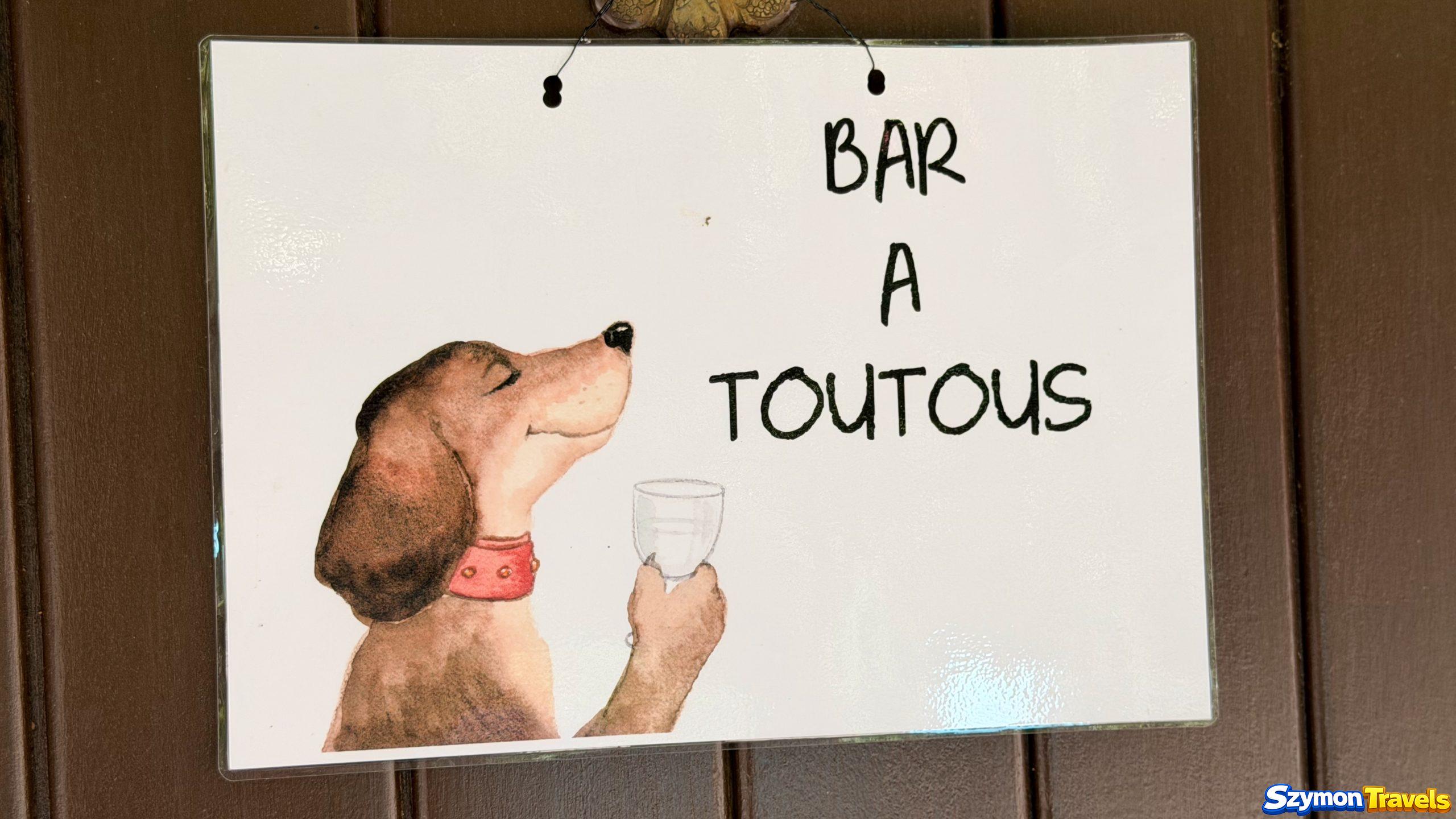 Tabliczka Bar à Toutous z miską dla psów przy ulicy w Dinan